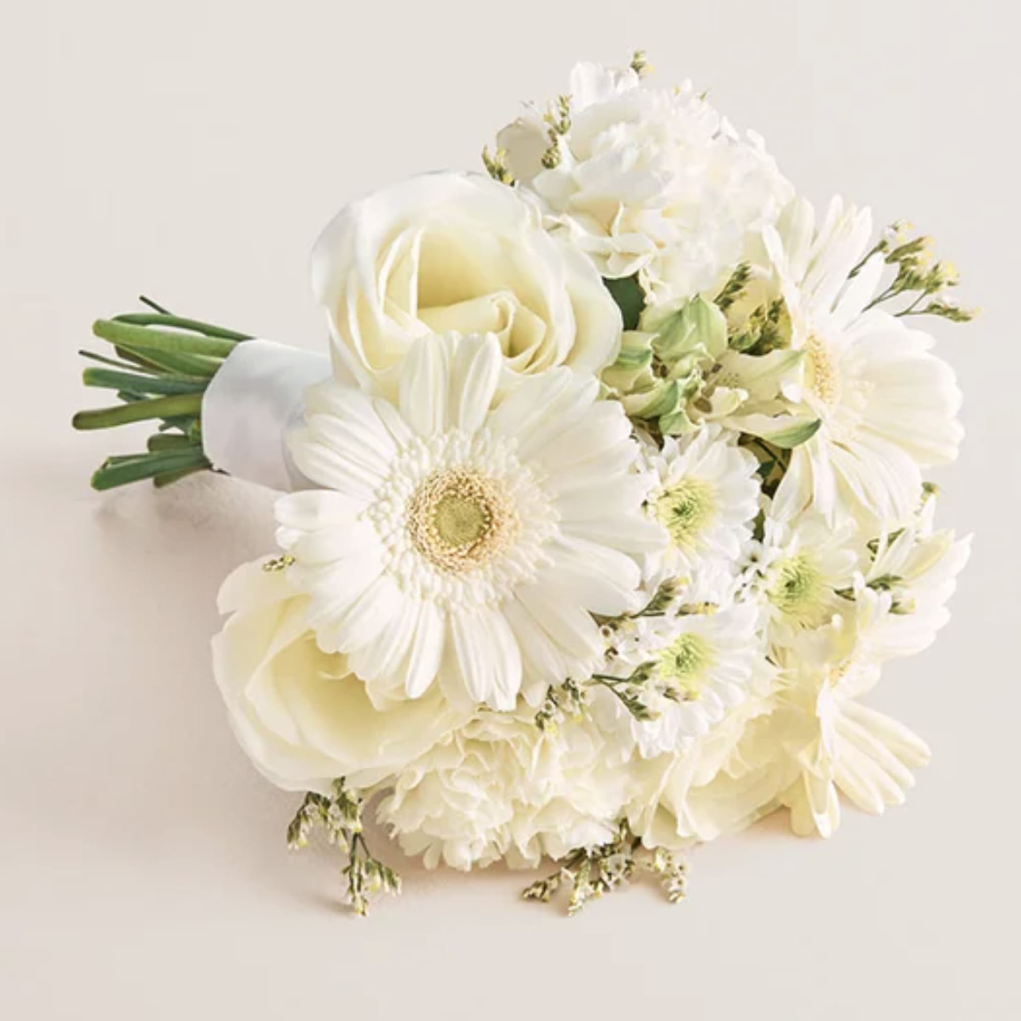 White bouquet with roses, gerbera daisies, and small filler flowers
