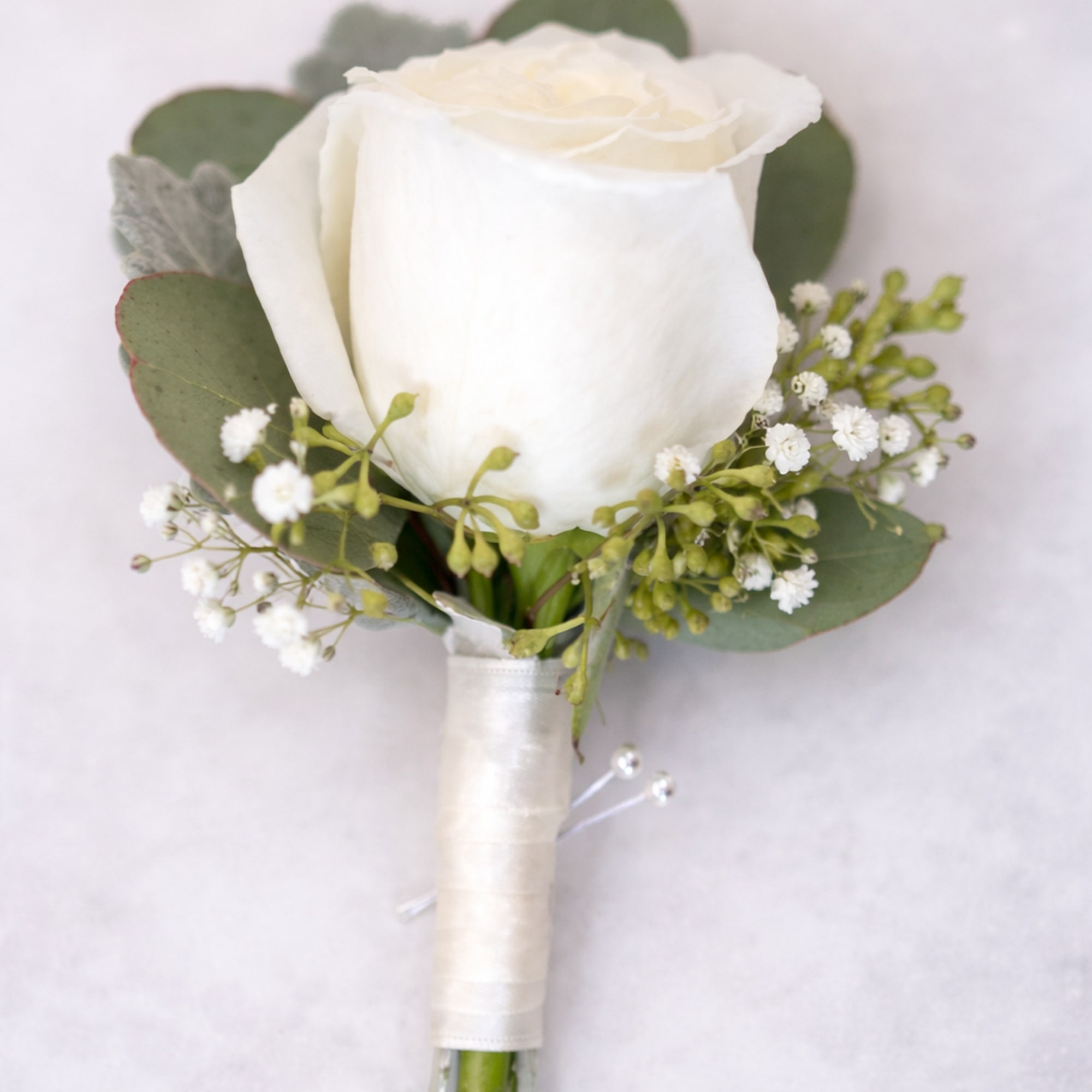 White rose boutonniere with eucalyptus and baby's breath