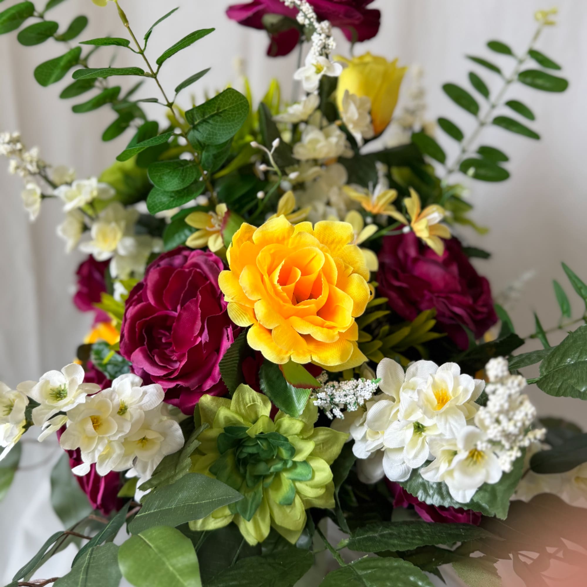 Bouquet of bright yellow, magenta, and white flowers with green foliage