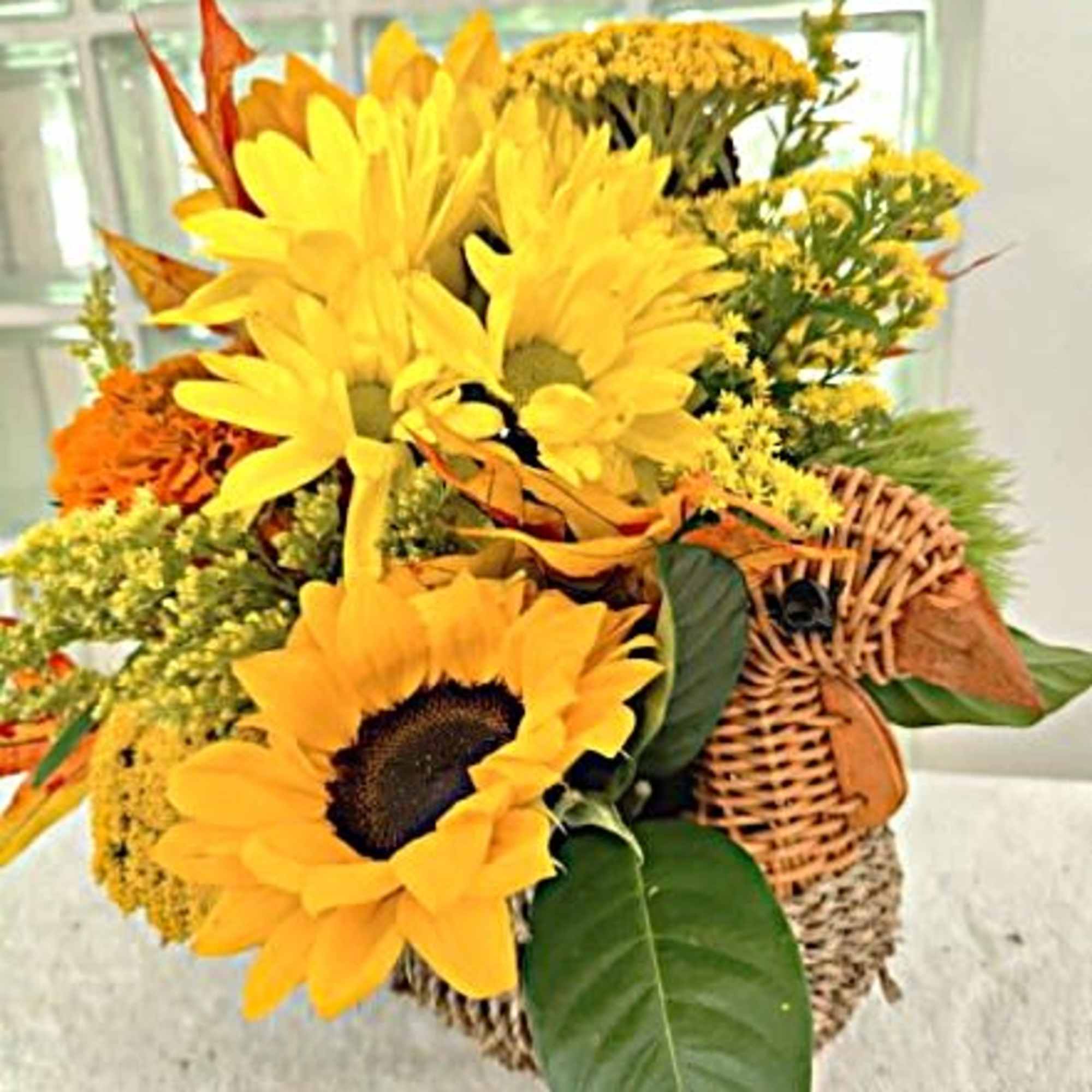 This cute little woven rattan turkey contains a beautiful, fall colored centerpiece
