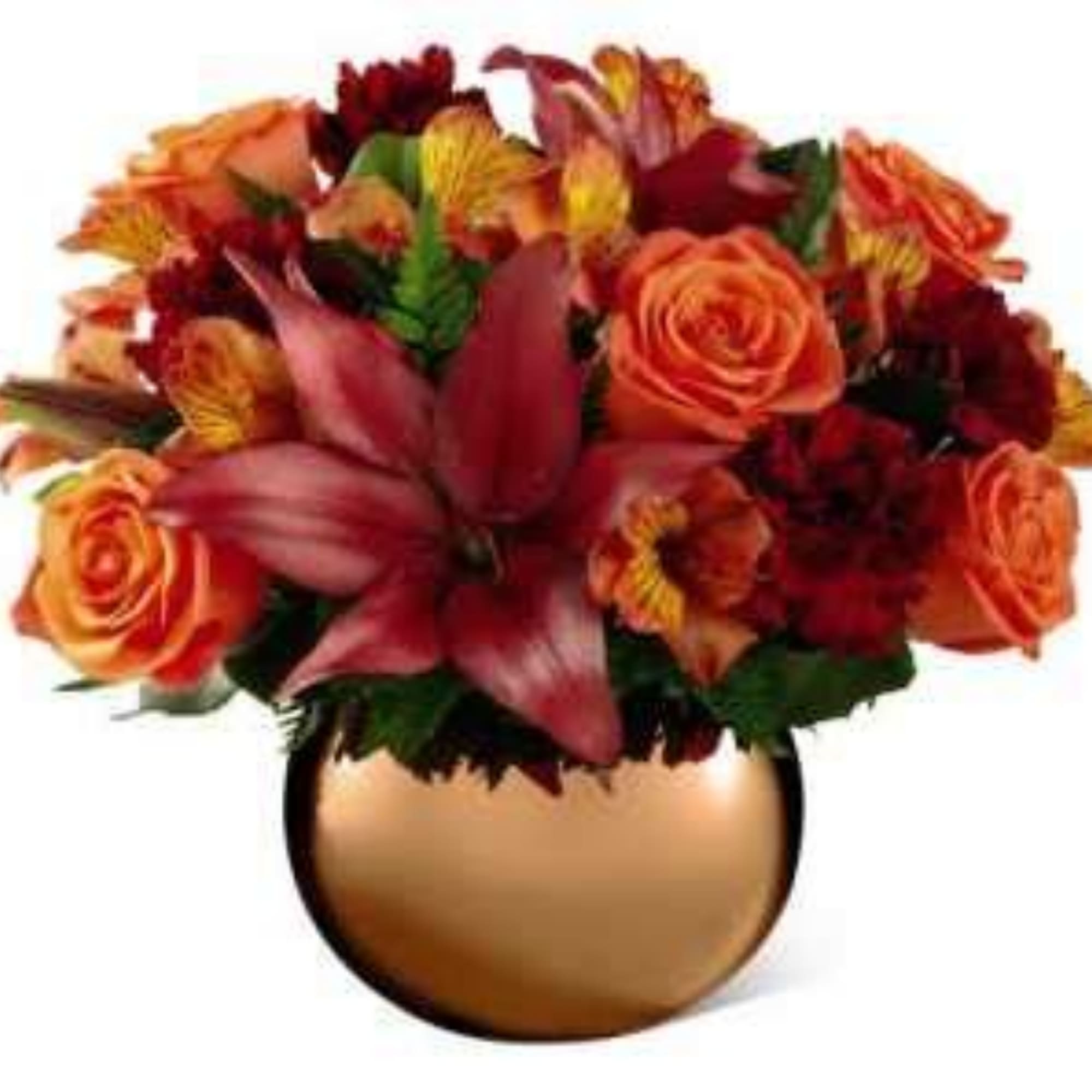 Orange and red flower arrangement in a round gold vase