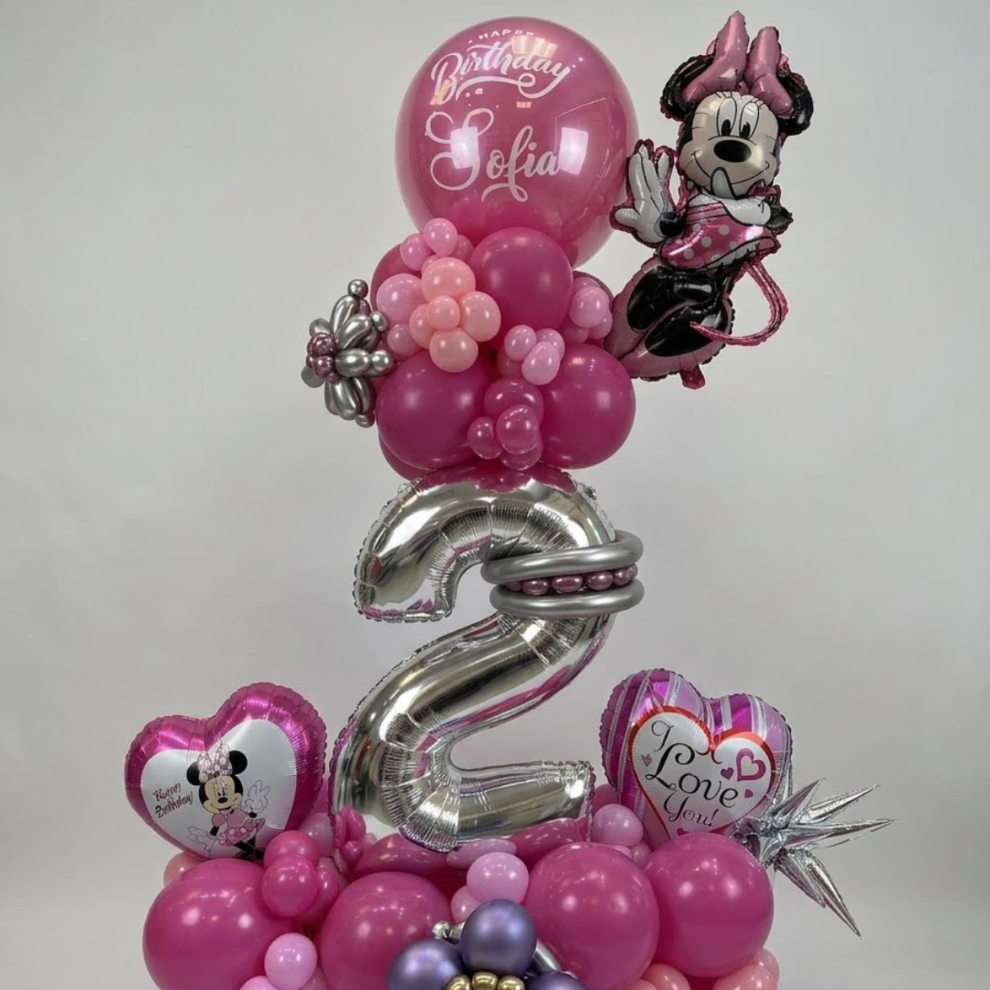 Pink birthday balloon arrangement with Minnie Mouse balloons and a large silver number 2.