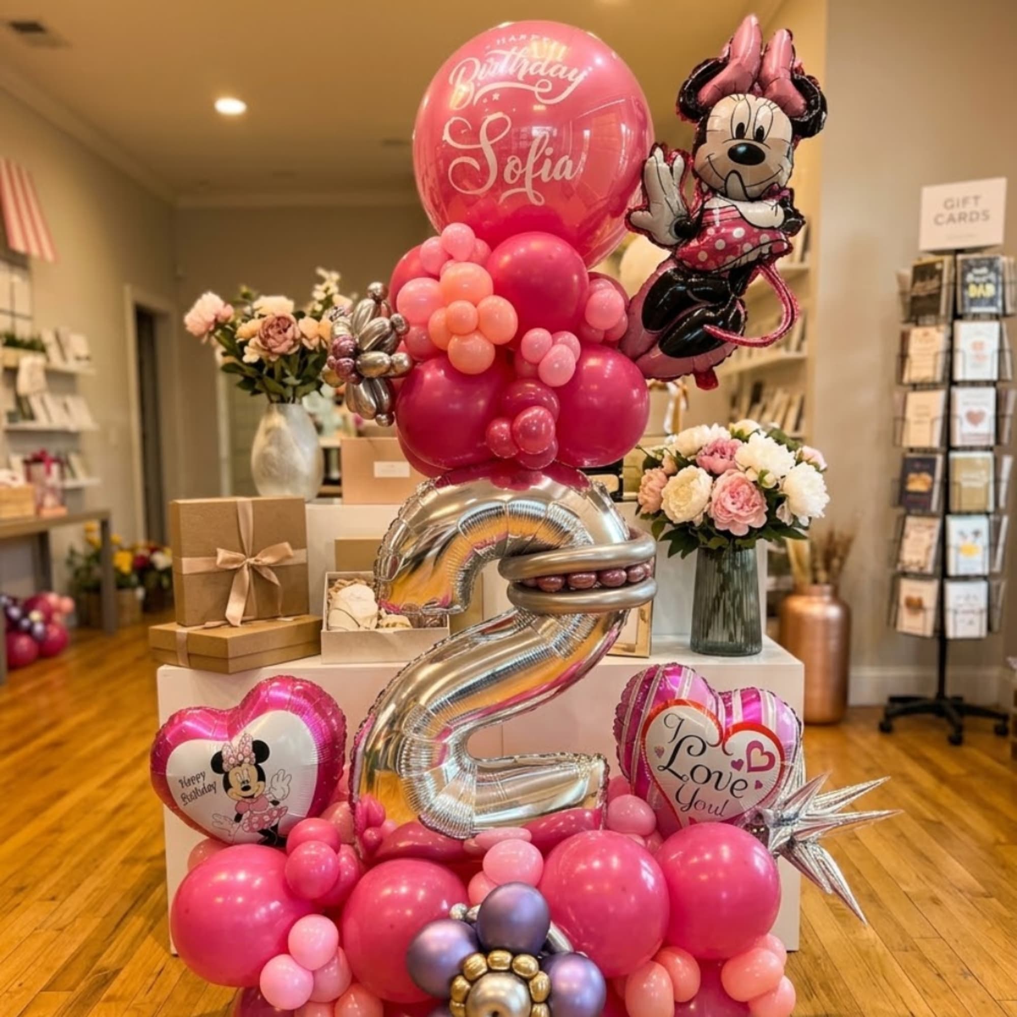 Pink birthday balloon display with Minnie Mouse and a large silver number 2