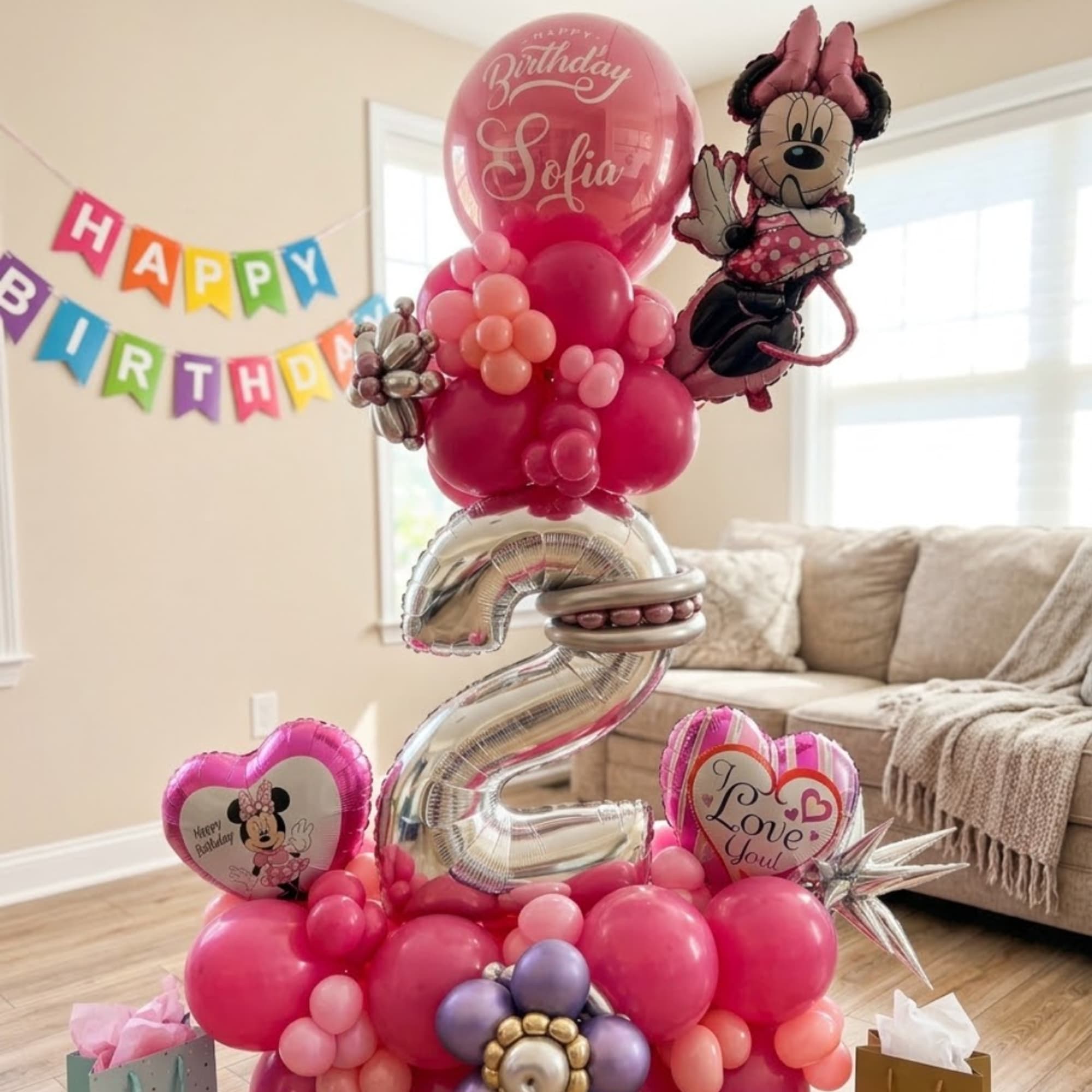Pink birthday balloon arrangement with Minnie Mouse balloons and a large silver number 2