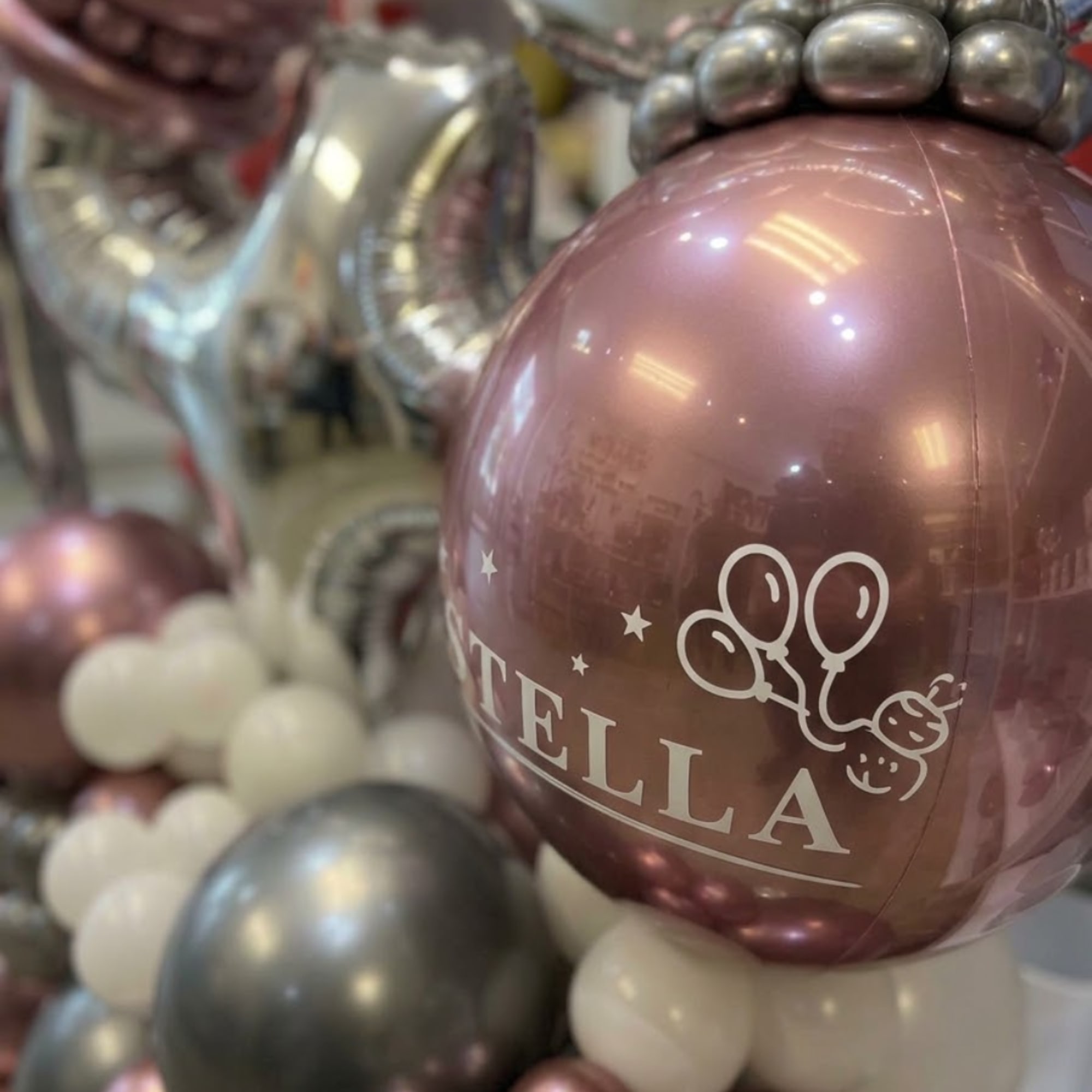 Pink and silver balloon arrangement with white balloon clusters