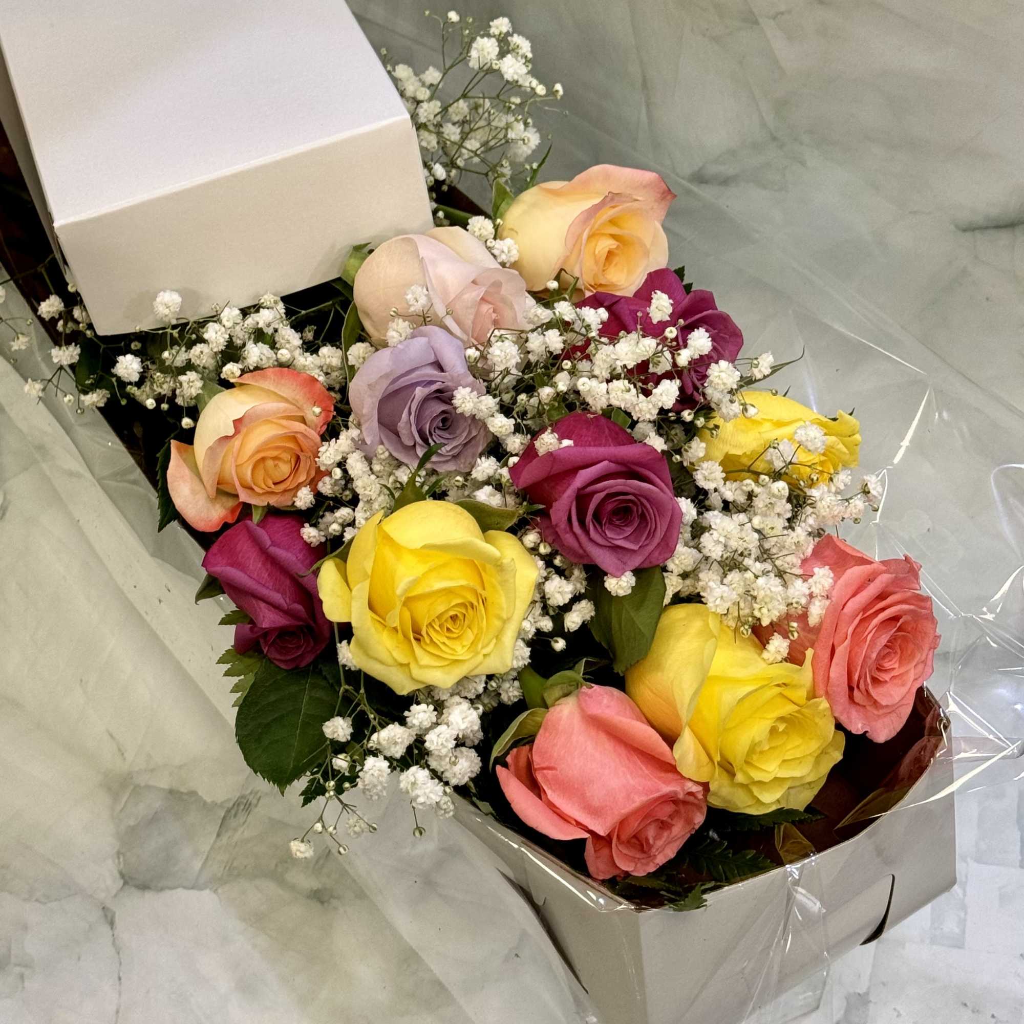 Boxed bouquet of multicolored roses with baby's breath