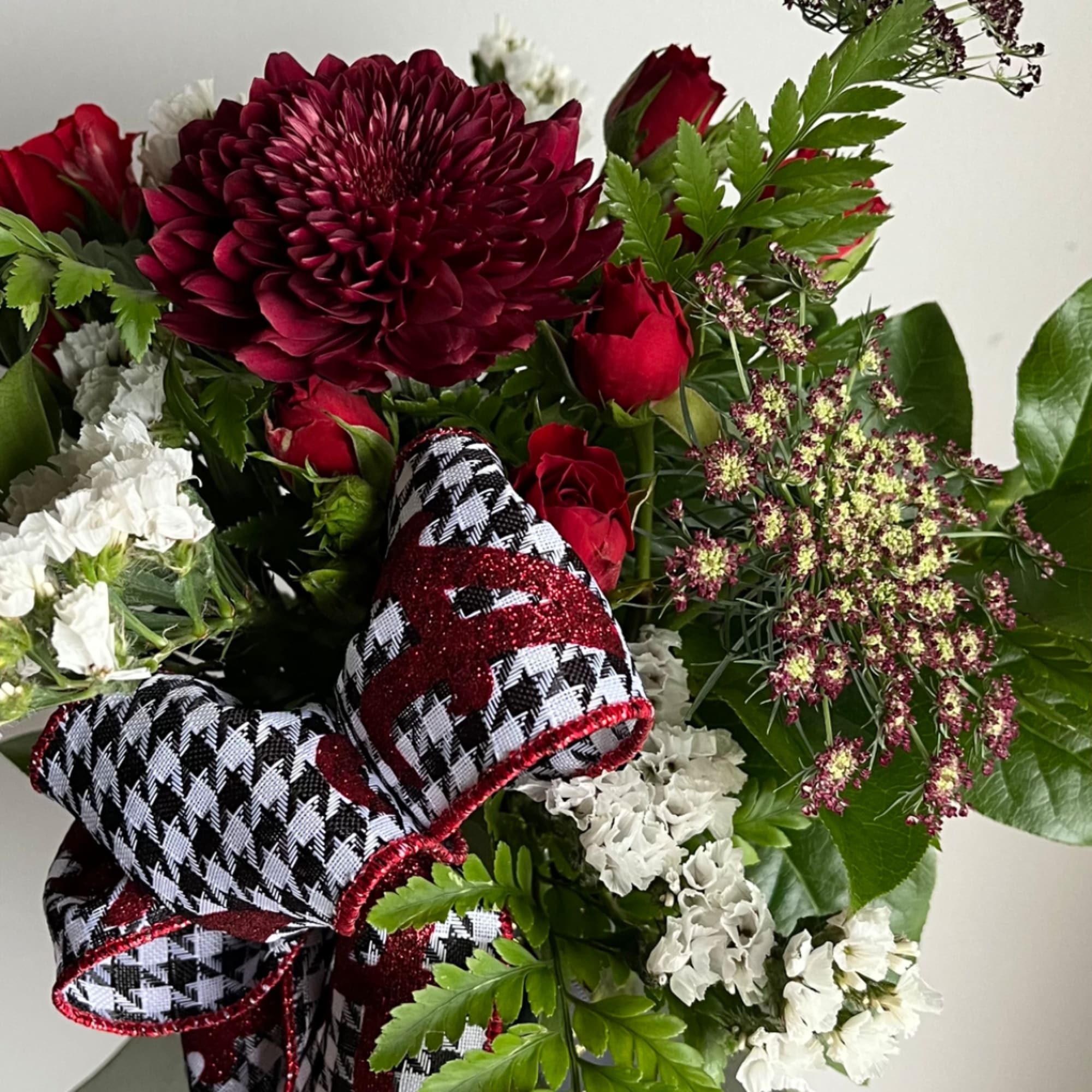 Bouquet of red and white flowers with a black-and-white ribbon bow