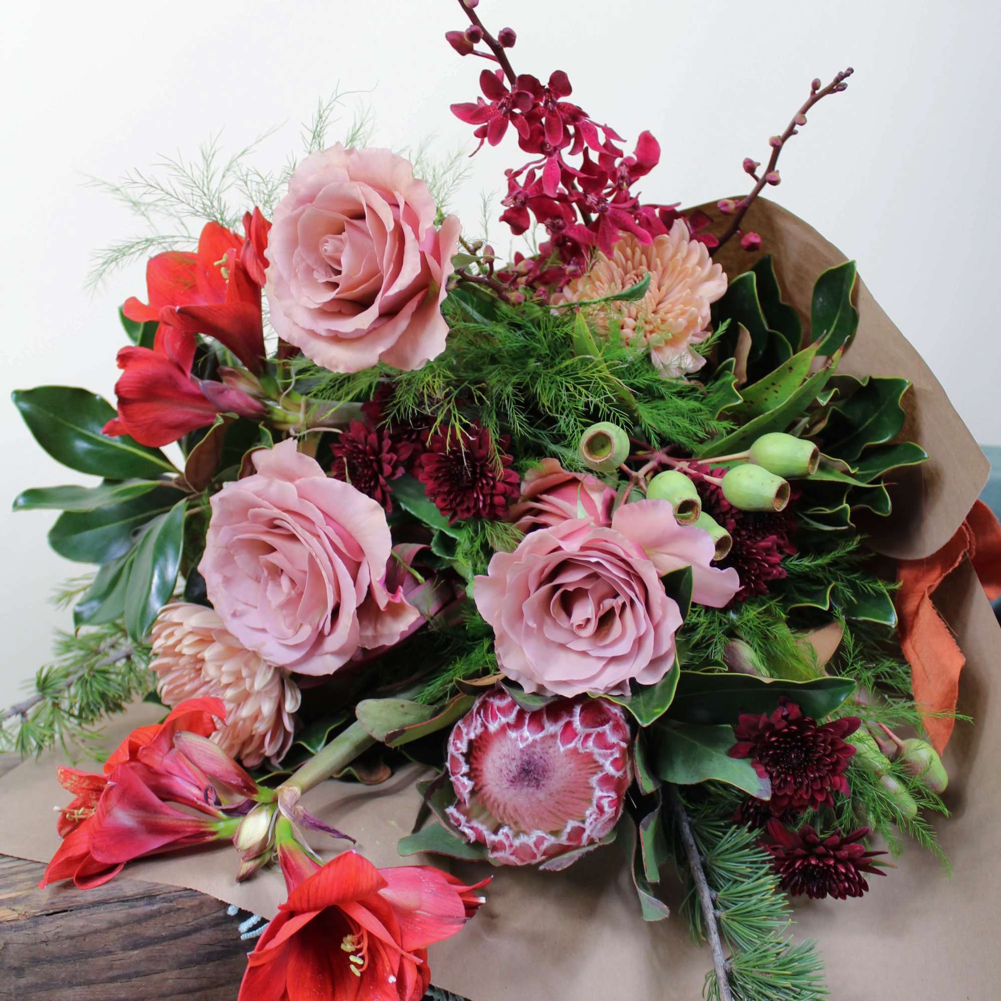 Bouquet of pink and red flowers wrapped in brown paper