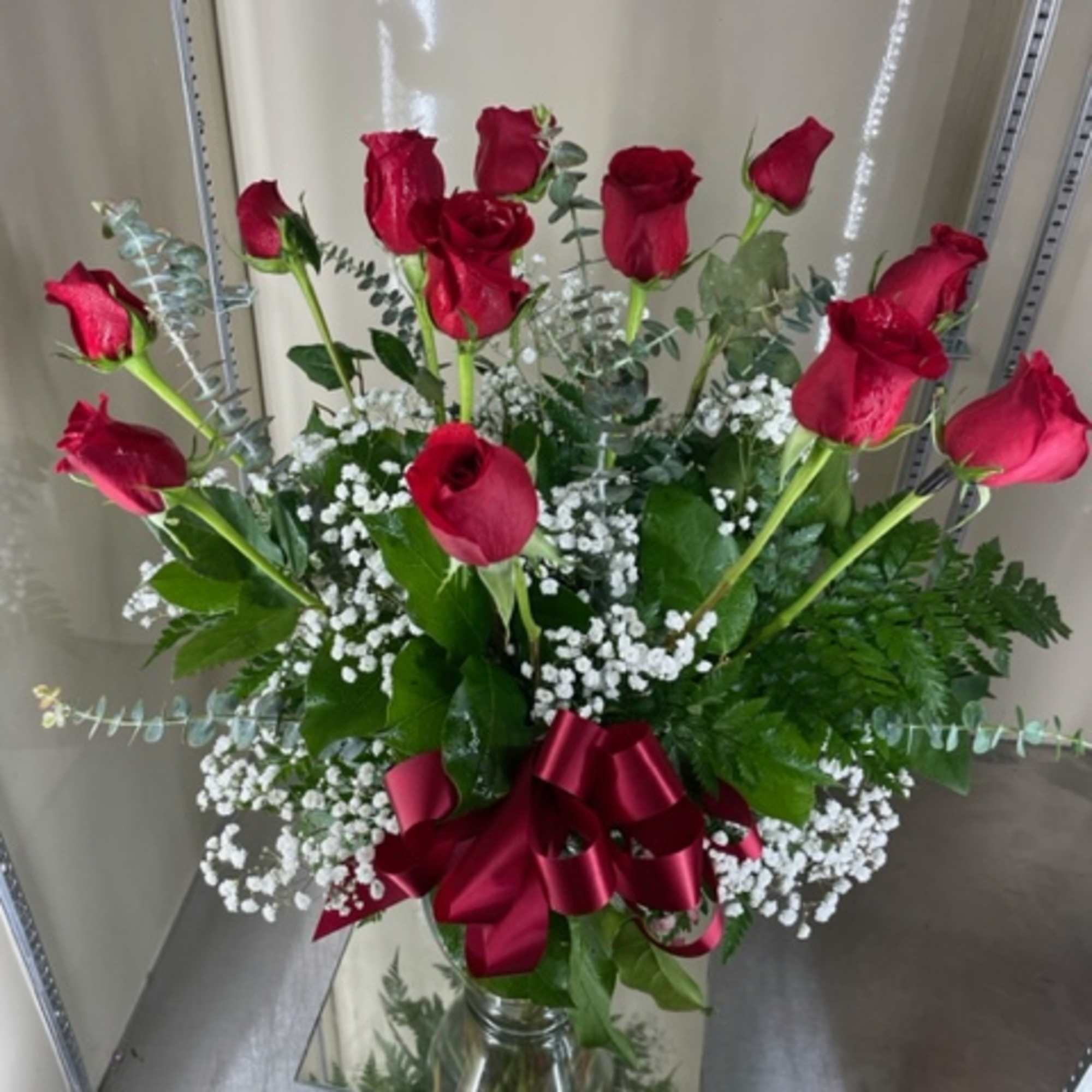 Bouquet of red roses with baby's breath in a glass vase