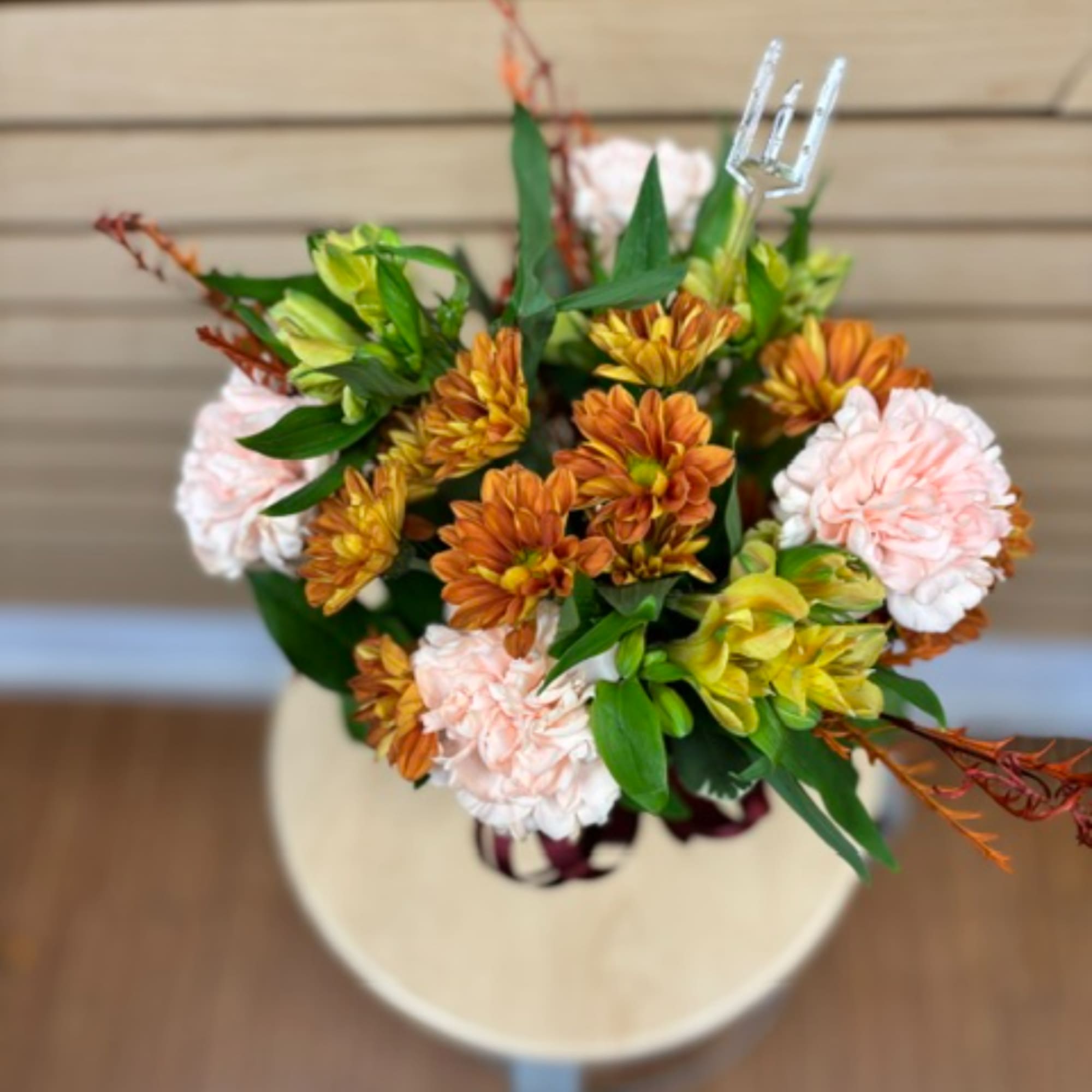Bouquet of orange, yellow, and pale pink flowers in a vase
