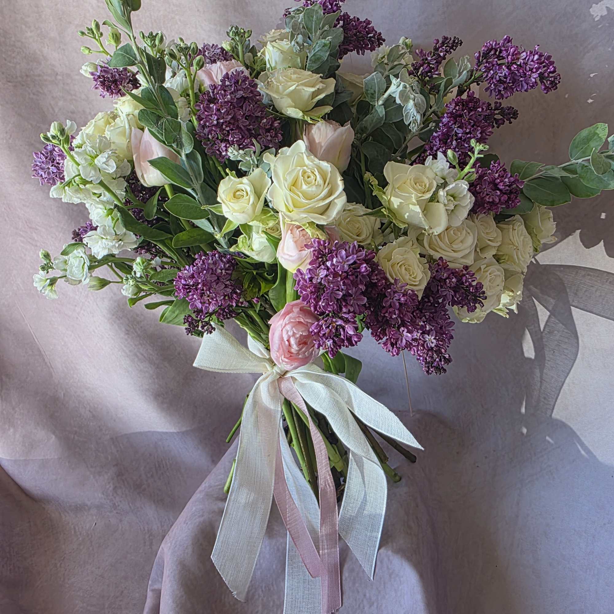 A delicate and romantic bouquet featuring soft lilac blooms, elegant white roses, photo 2 of 2