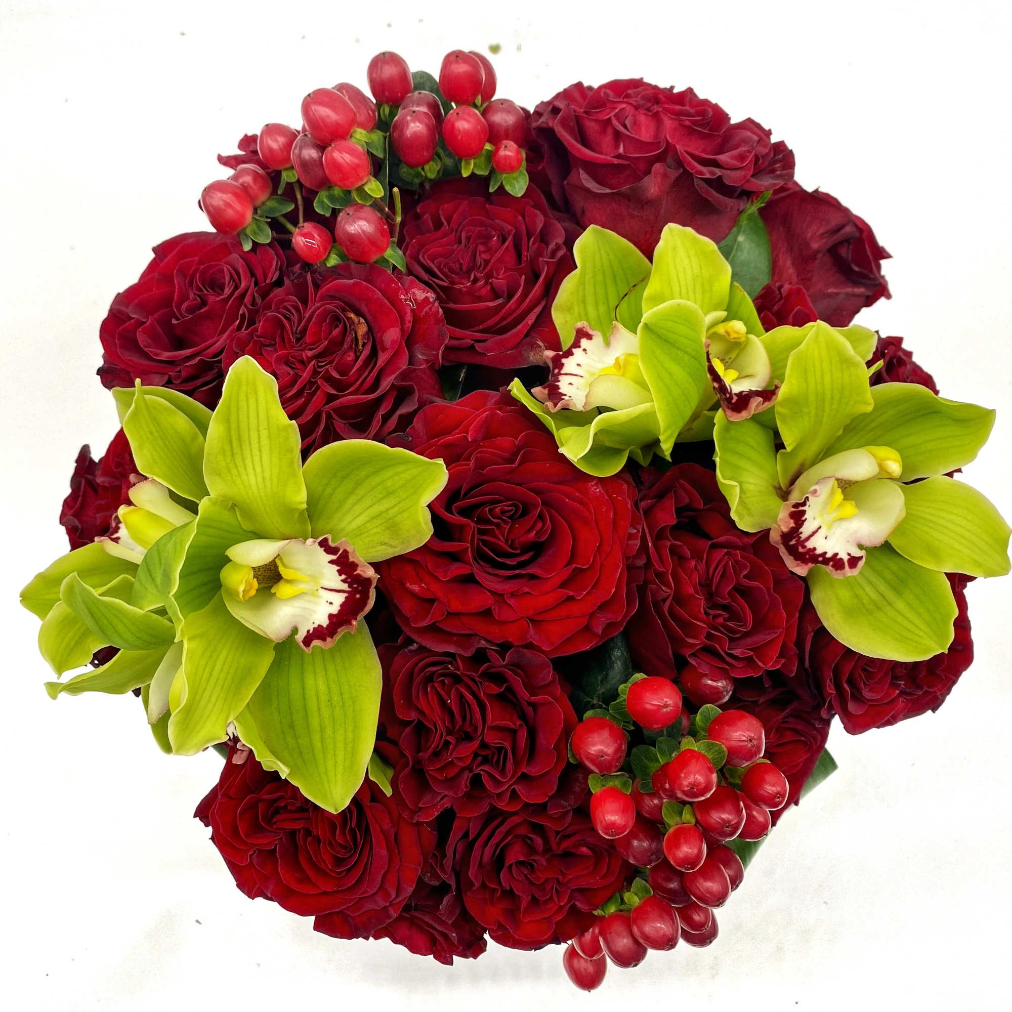 Bouquet of red roses with green orchids and berry accents