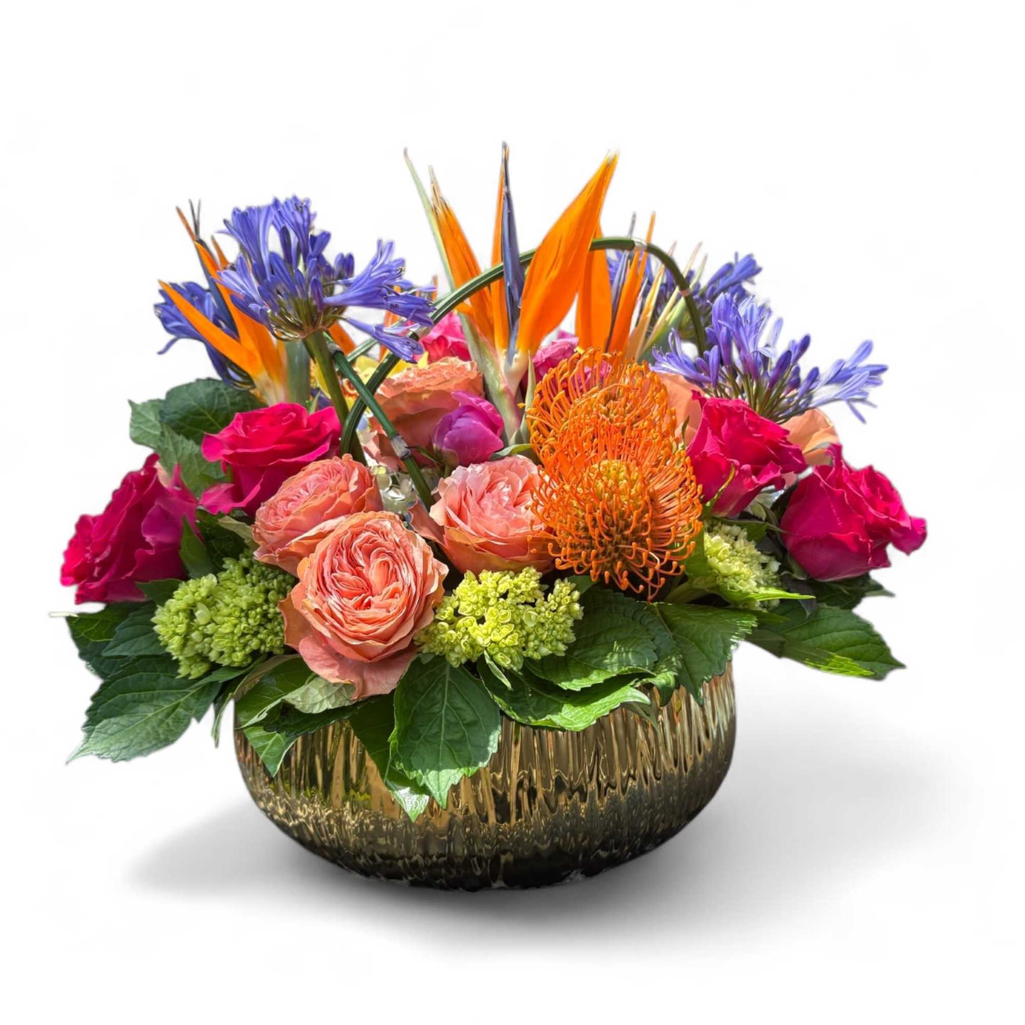 Mixed bouquet in a gold textured bowl vase with orange and purple blooms