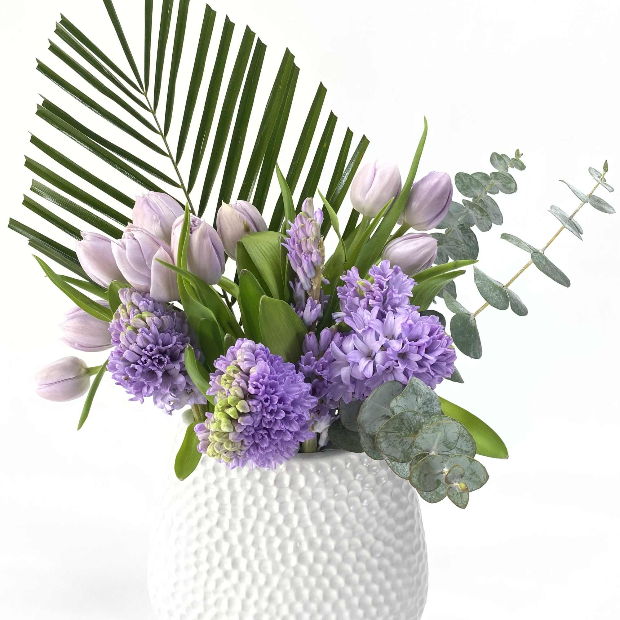 Lavender tulips and purple hyacinths in a white textured vase, photo 2 of 2