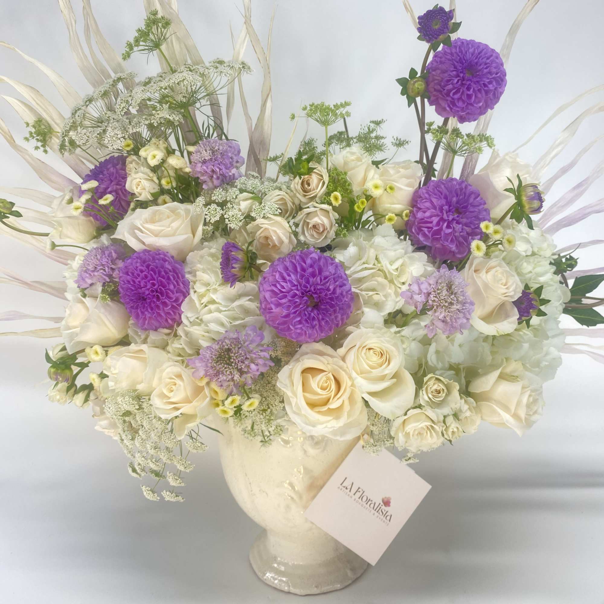 Cream and purple floral arrangement in a glass vase