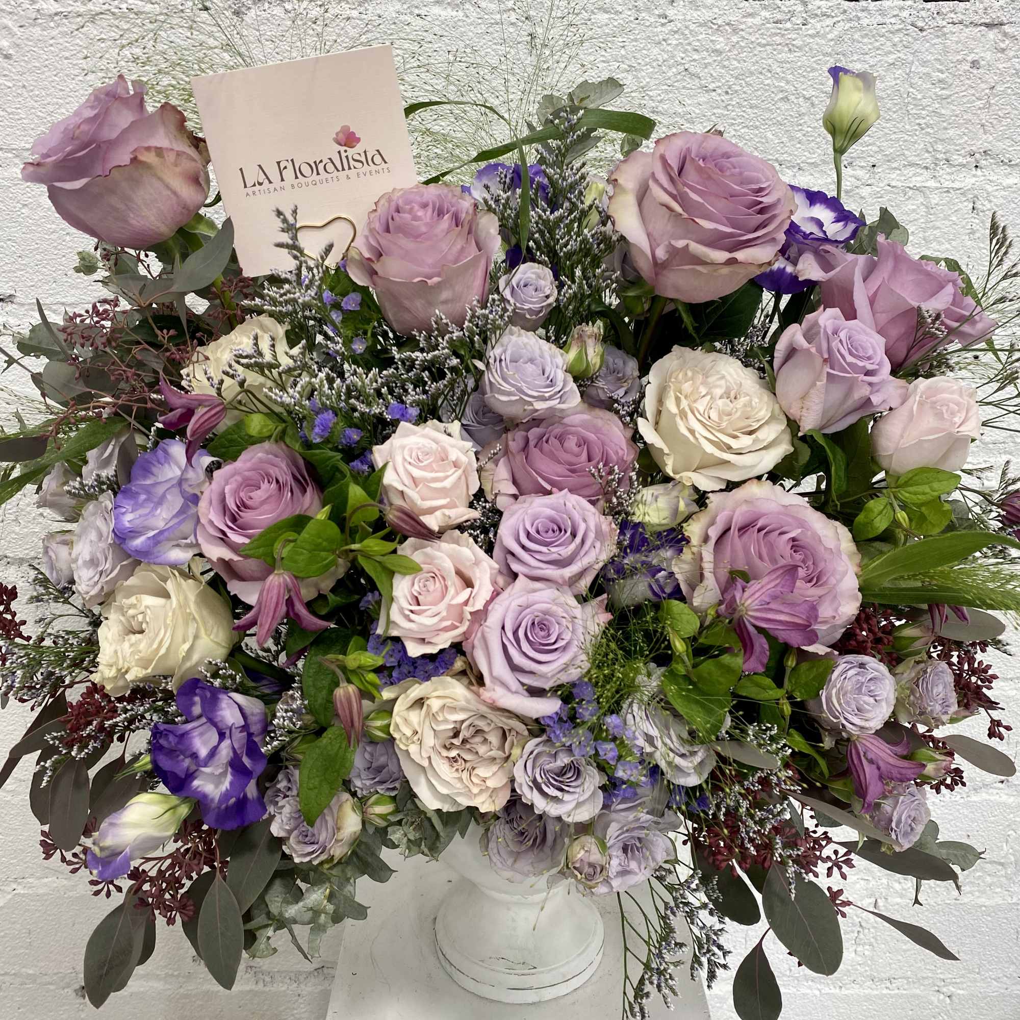 Lavender and white rose bouquet in a white pedestal vase