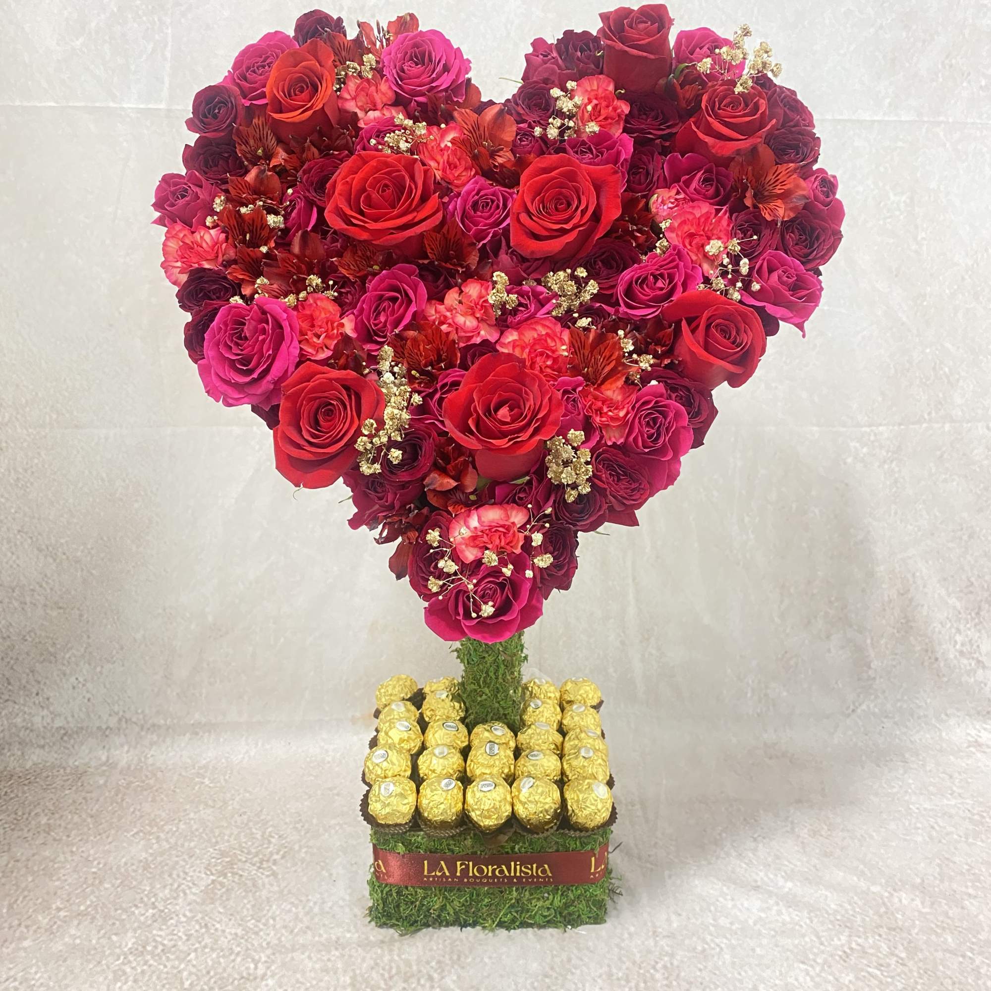 Heart-shaped rose arrangement with chocolates on a square base