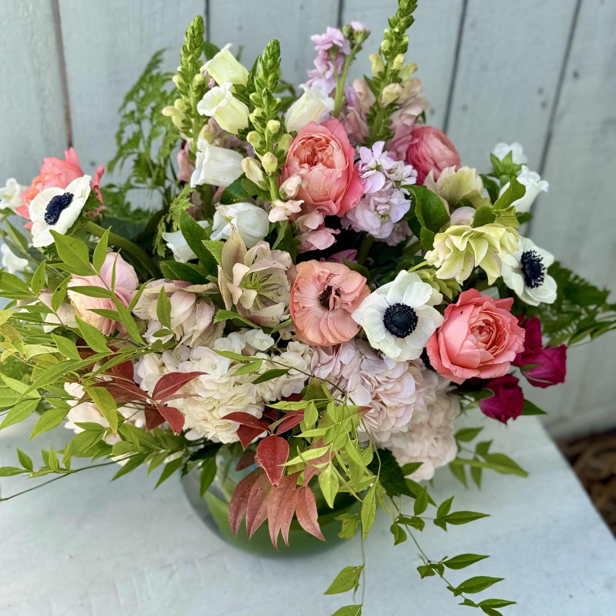 Mixed pink and white bouquet with anemones and roses in a vase