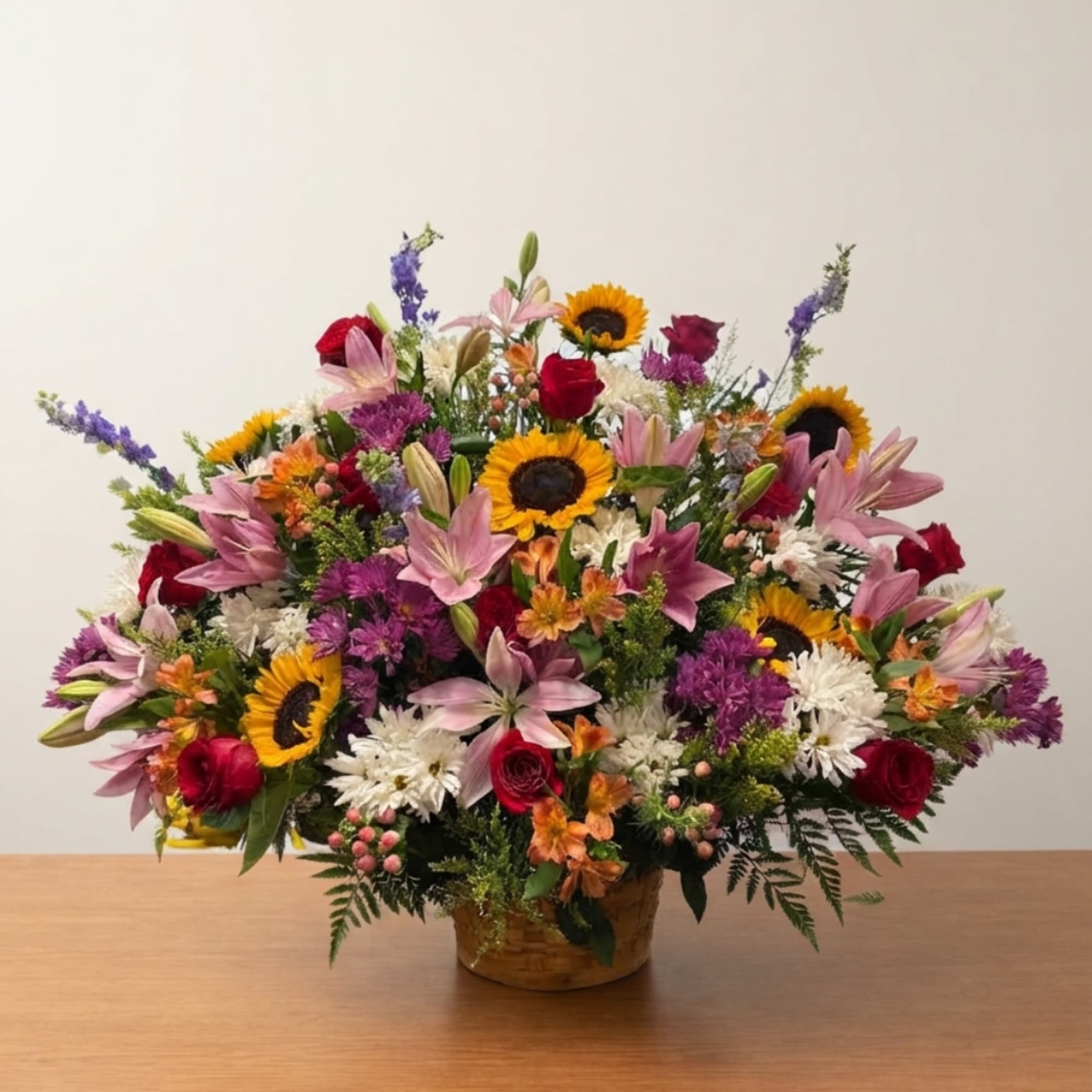 Mixed bouquet with sunflowers, lilies, and roses in a basket