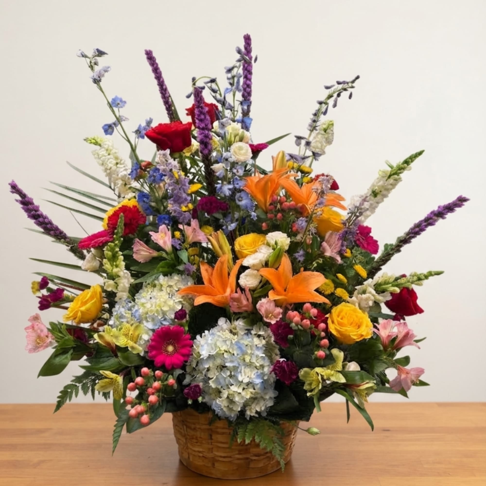 Colorful mixed flower arrangement in a woven basket