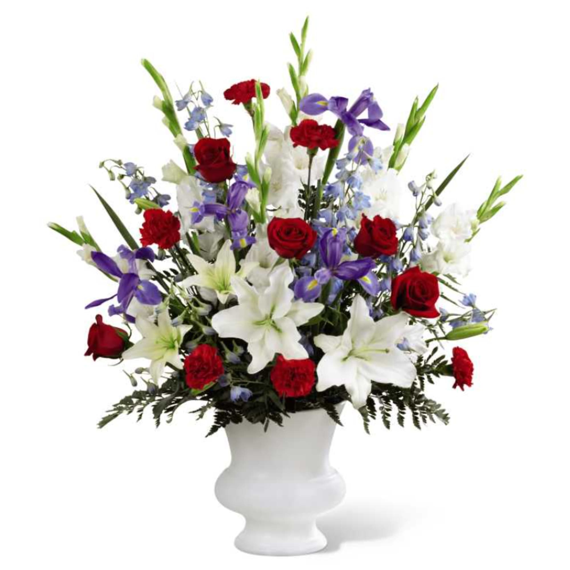 Red roses and white lilies with purple flowers in a white vase