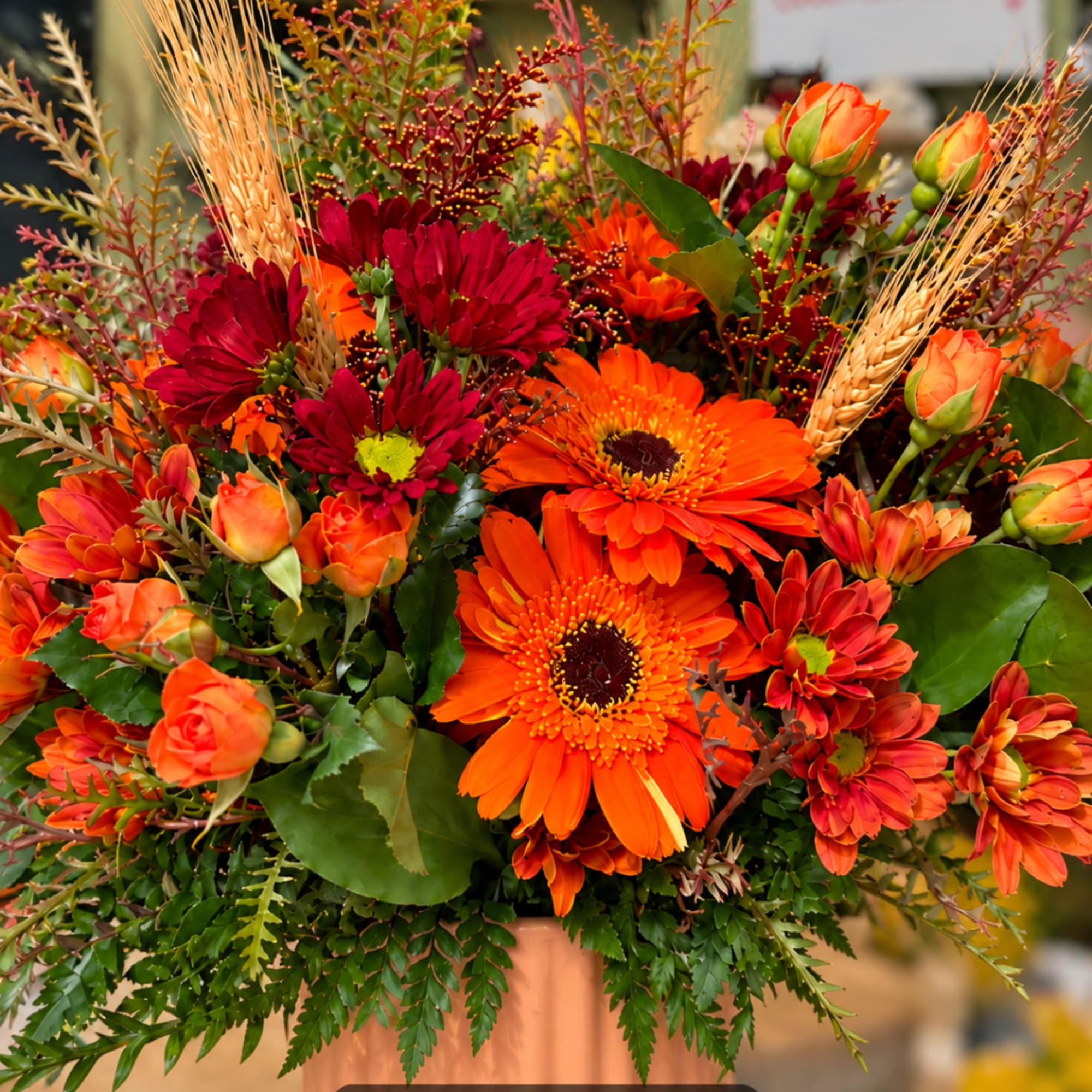 Orange and burgundy flowers arranged in a vase