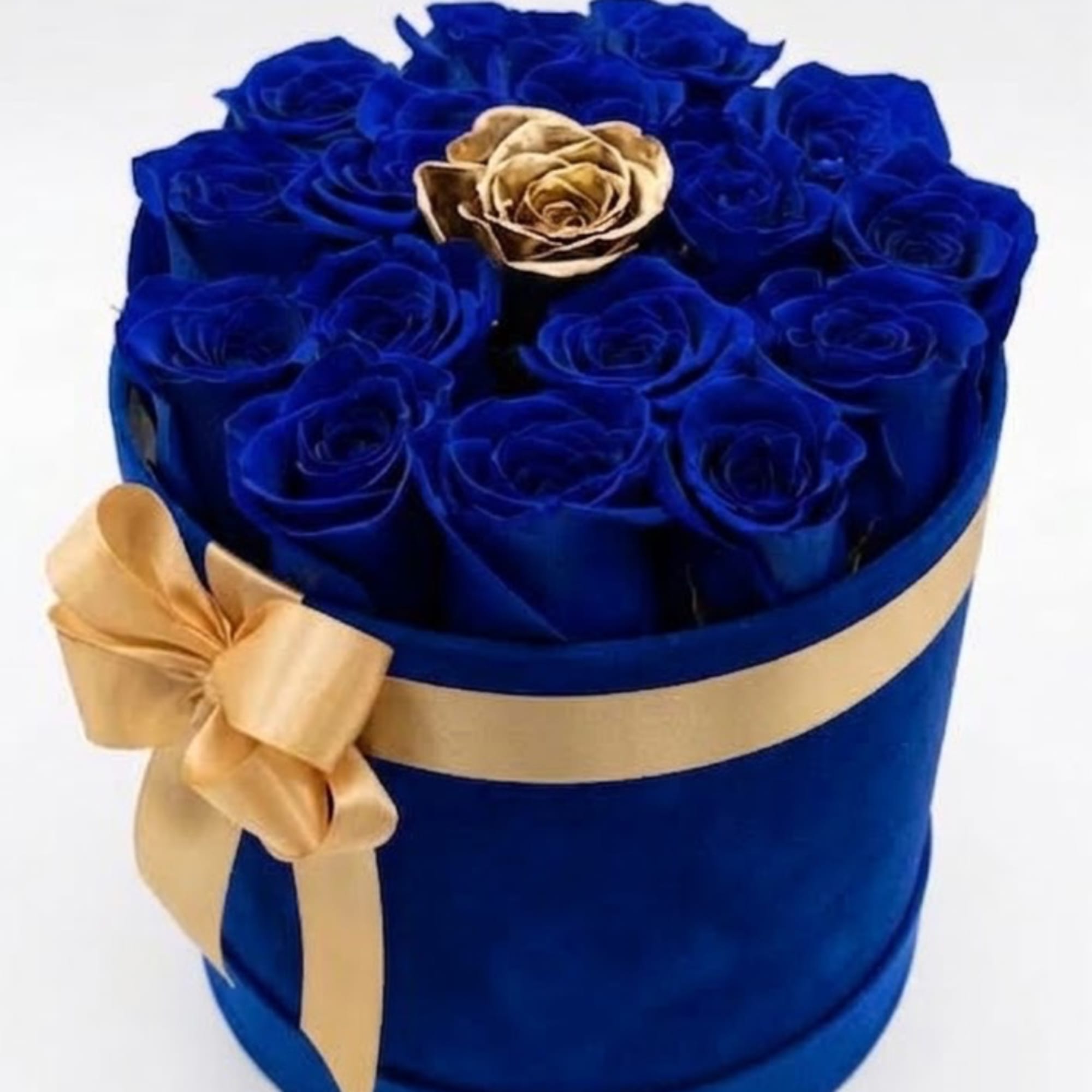 Blue roses in a round box with a gold ribbon and one gold rose