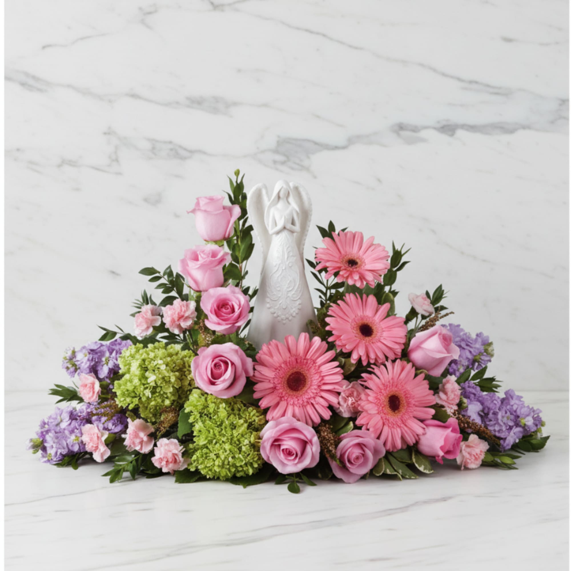 Pink and purple floral arrangement with an angel figurine in the center