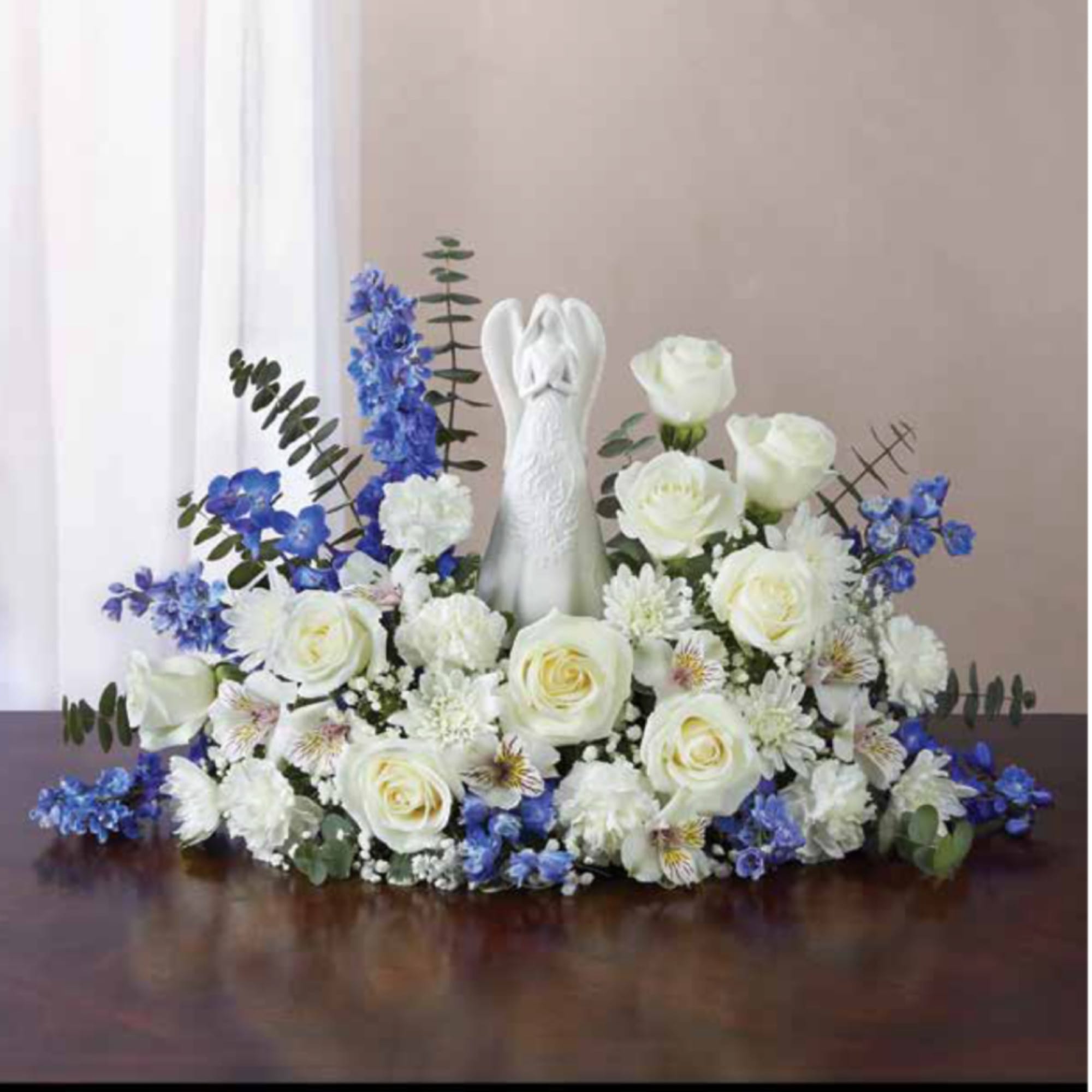 White floral arrangement with a rabbit figurine and blue accents