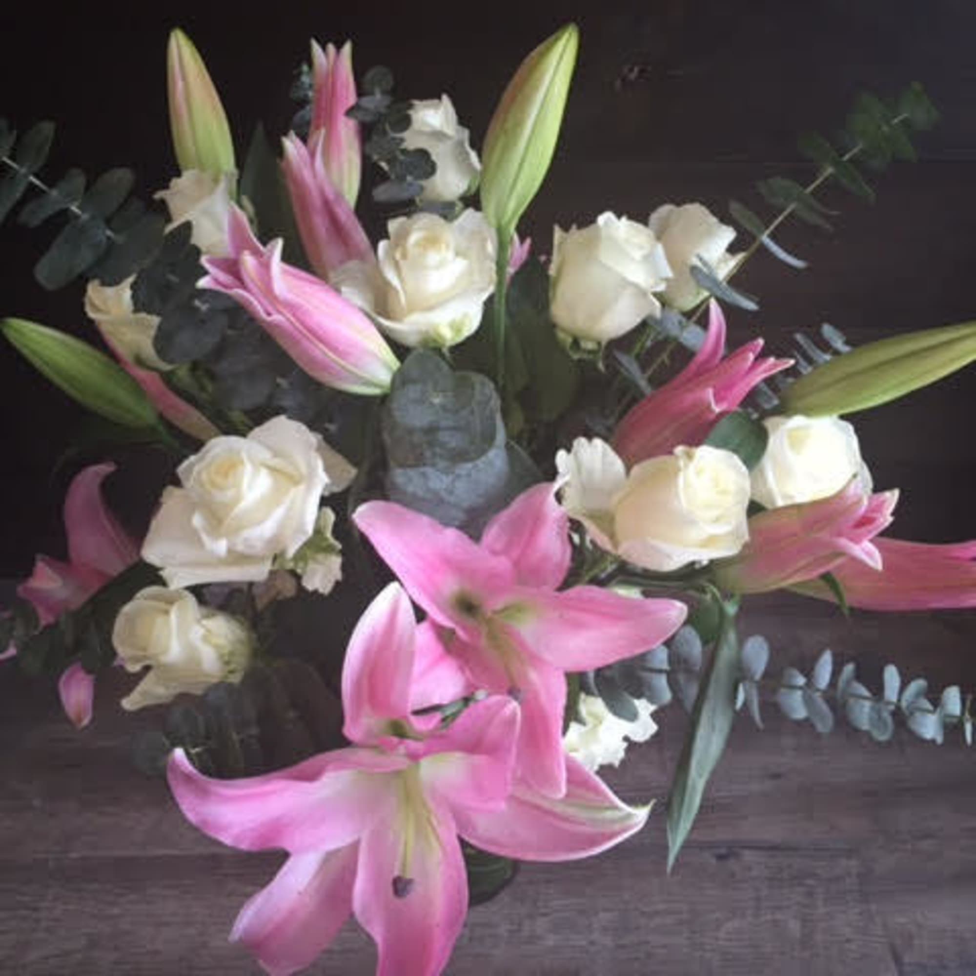 Pink lilies and white roses arranged in a vase