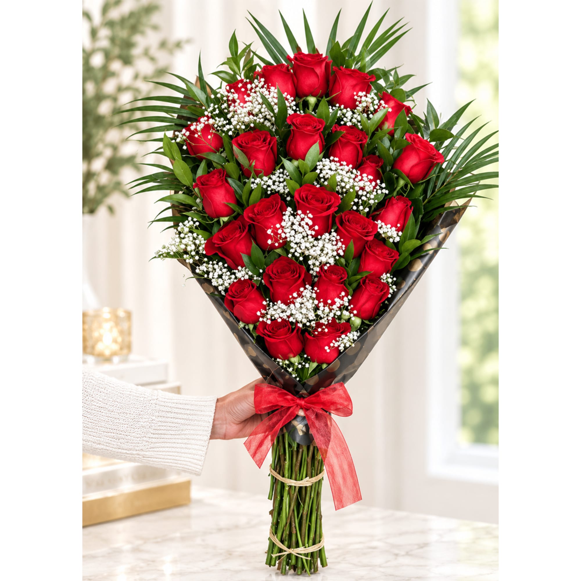 Bouquet of red roses with baby's breath wrapped in dark paper and tied with a red ribbon