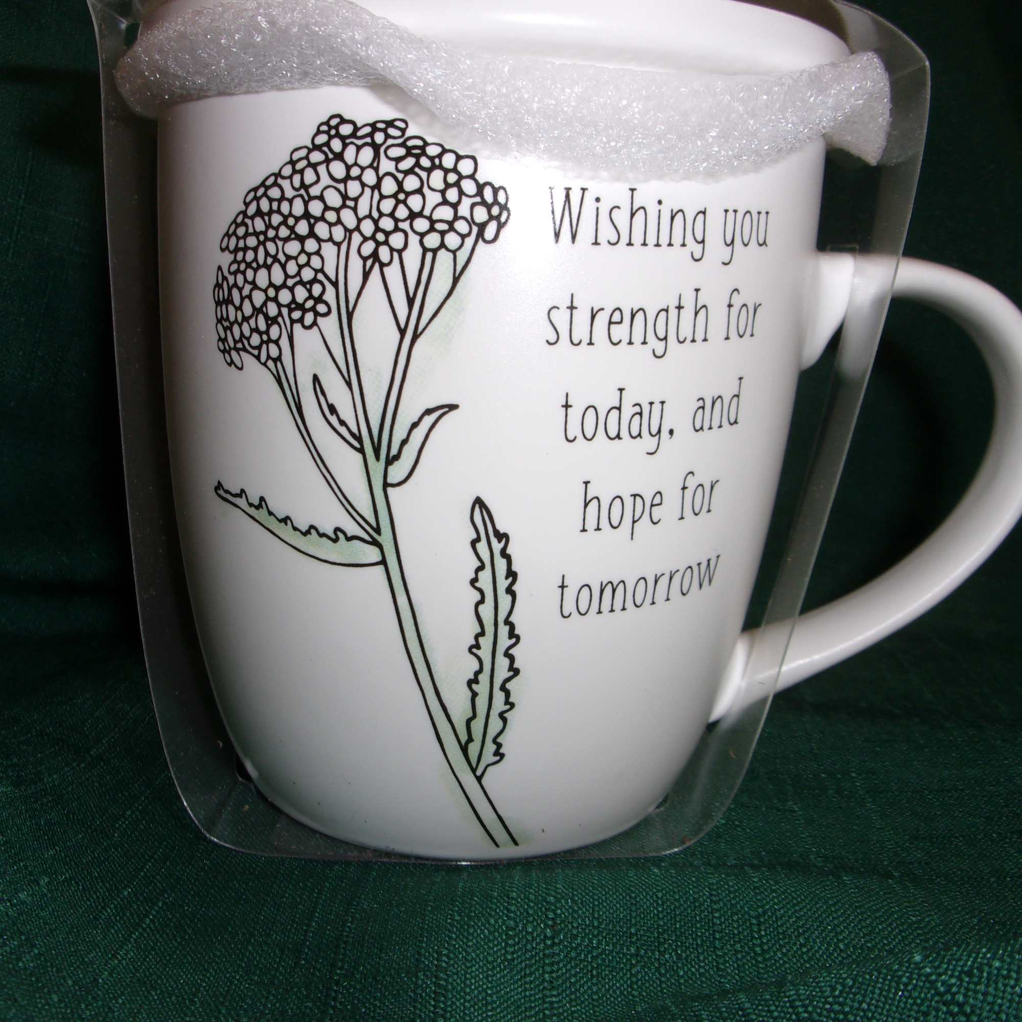 White mug with a floral line drawing and printed message in a clear gift wrap