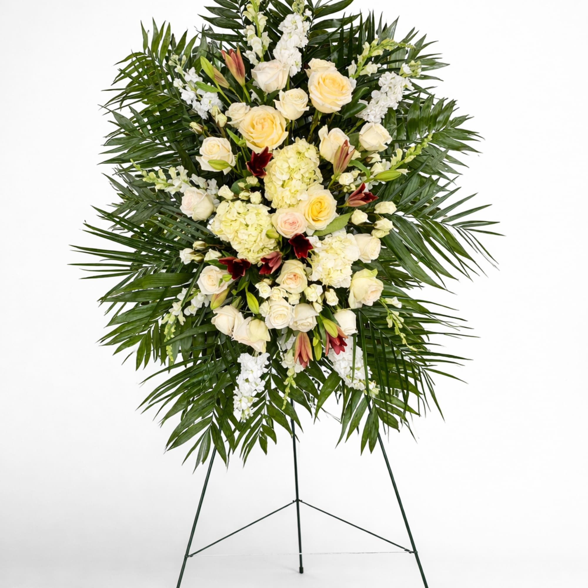 Tall standing spray of ivory roses and hydrangeas with palm fronds on a metal easel