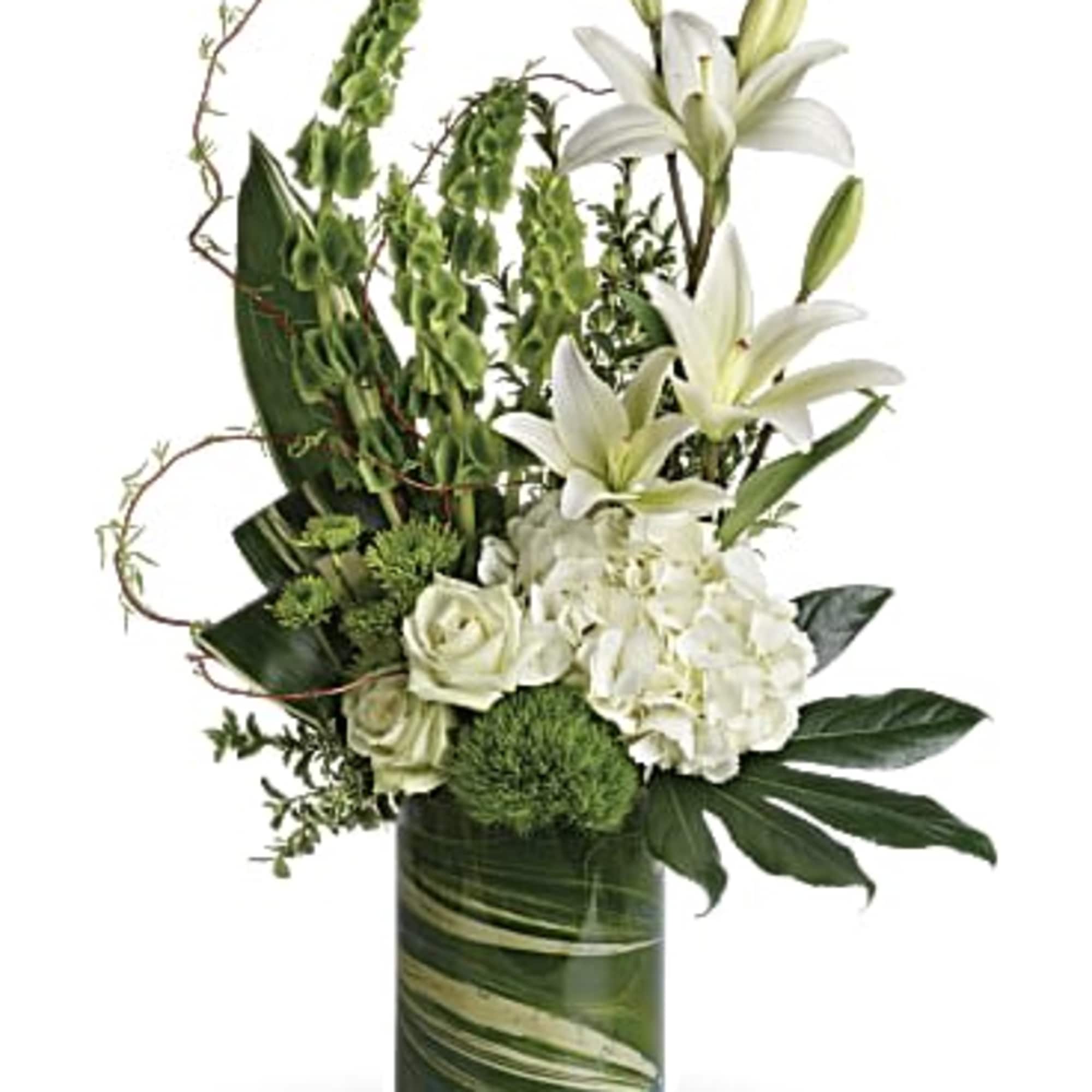 White lilies and roses arranged in a green glass vase