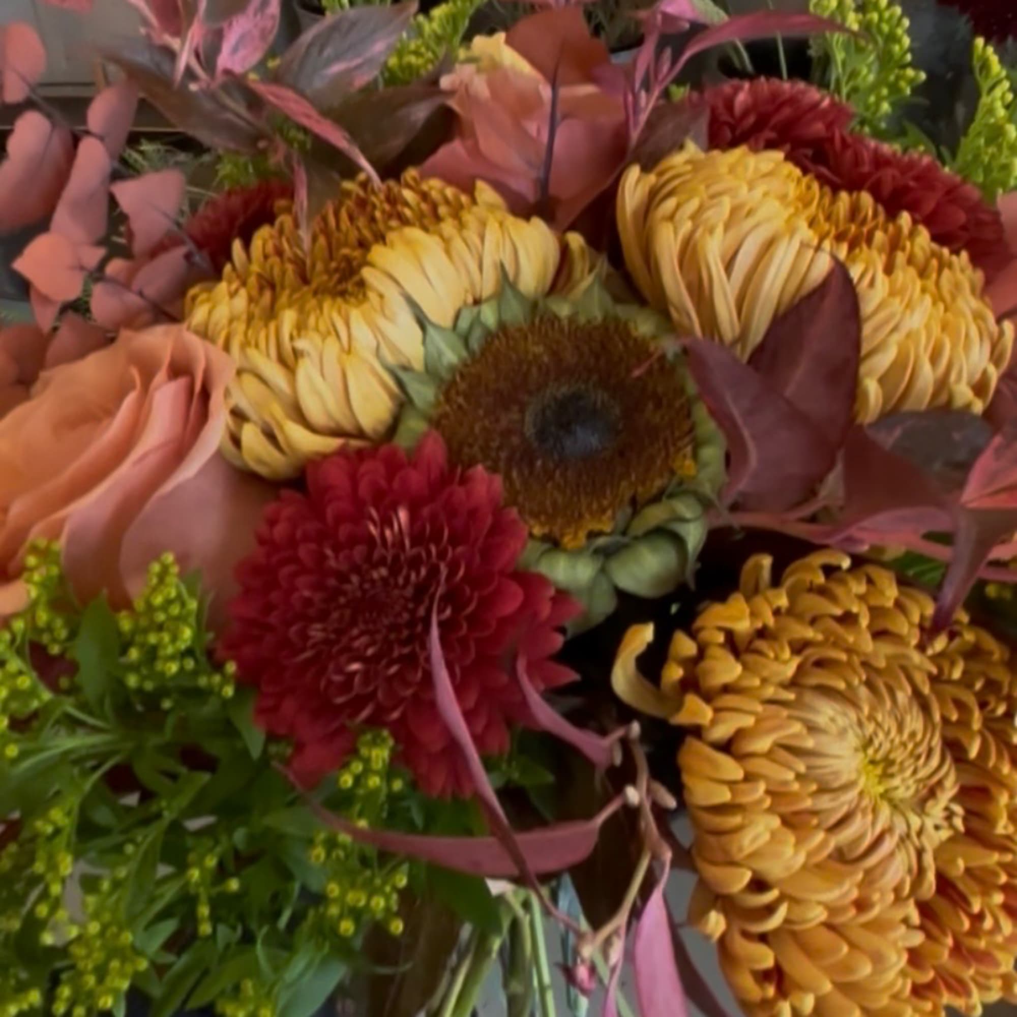 Mixed bouquet with chrysanthemums, a rose, and warm autumn-toned blooms