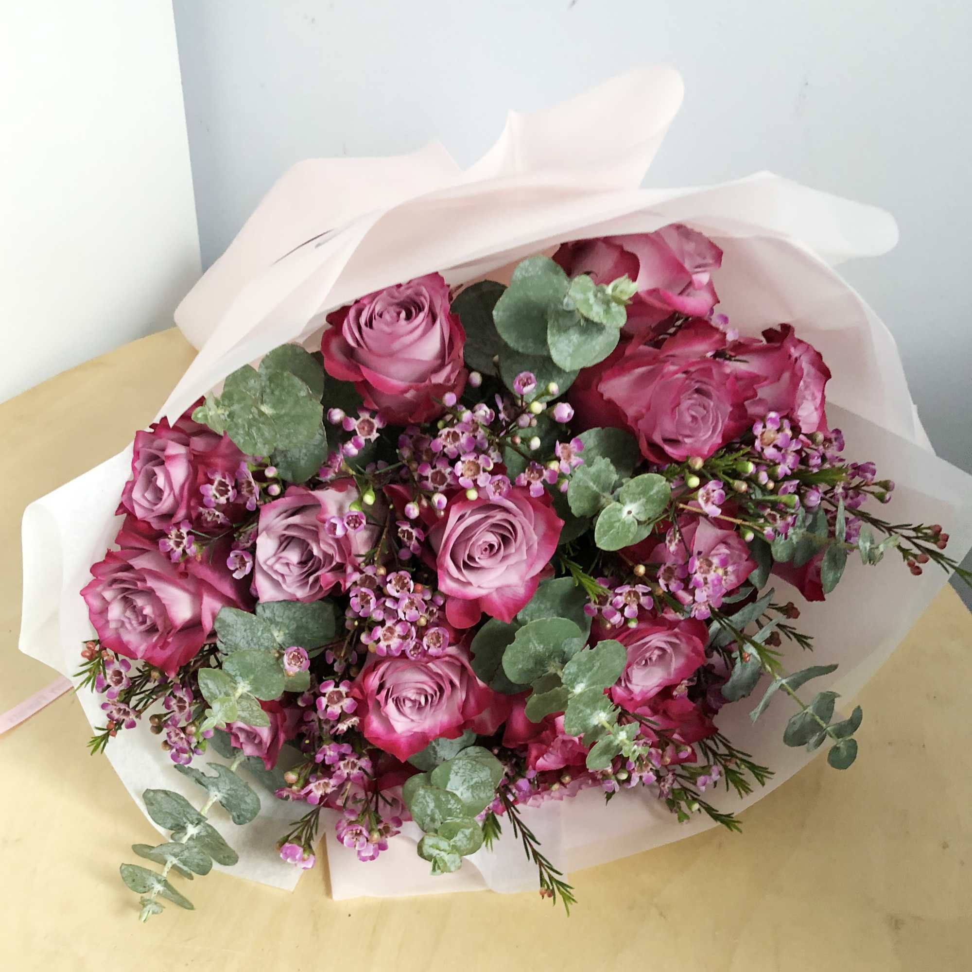 Bouquet of pink roses with small purple filler flowers and eucalyptus