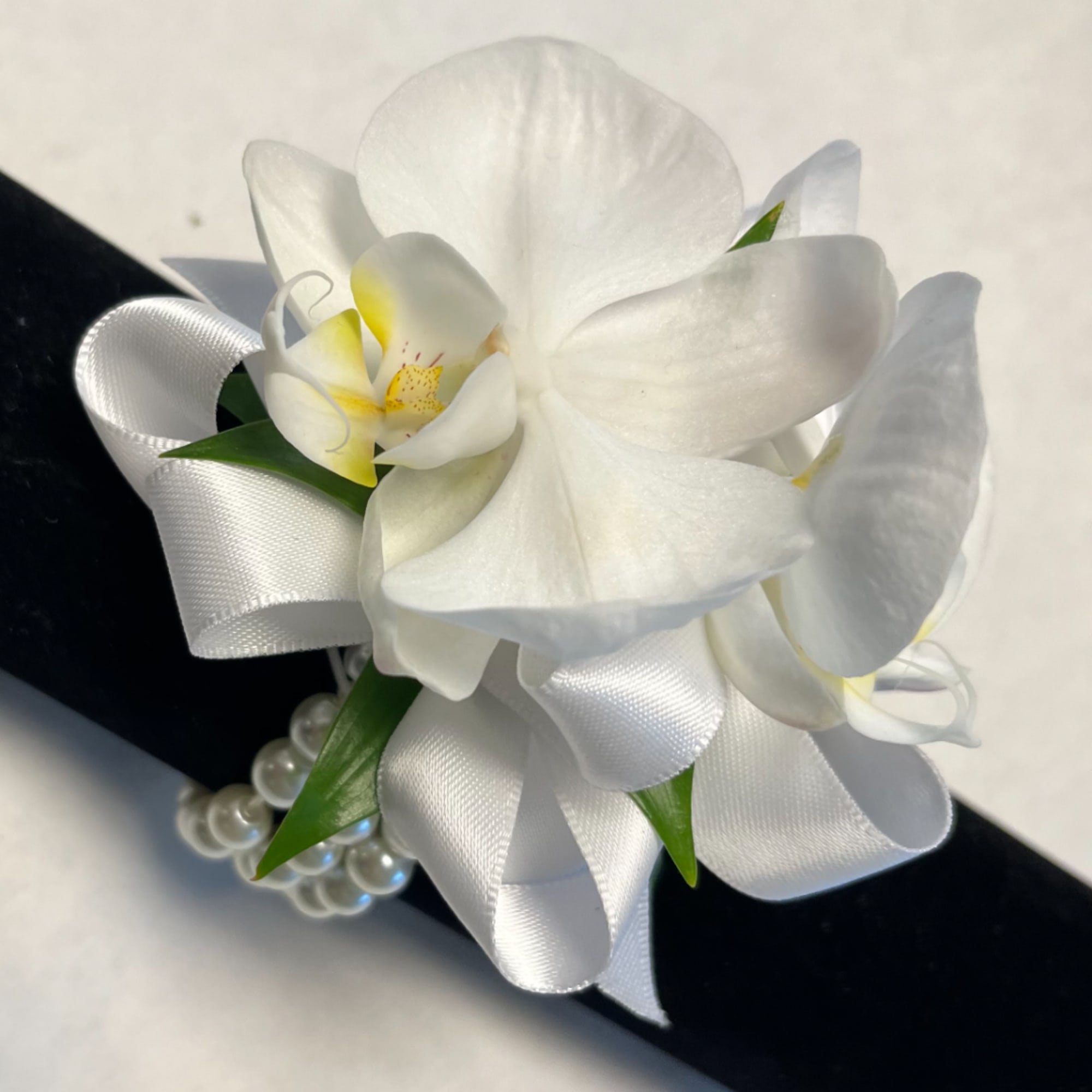 White orchid corsage with satin ribbon and pearl accents, photo 3 of 3