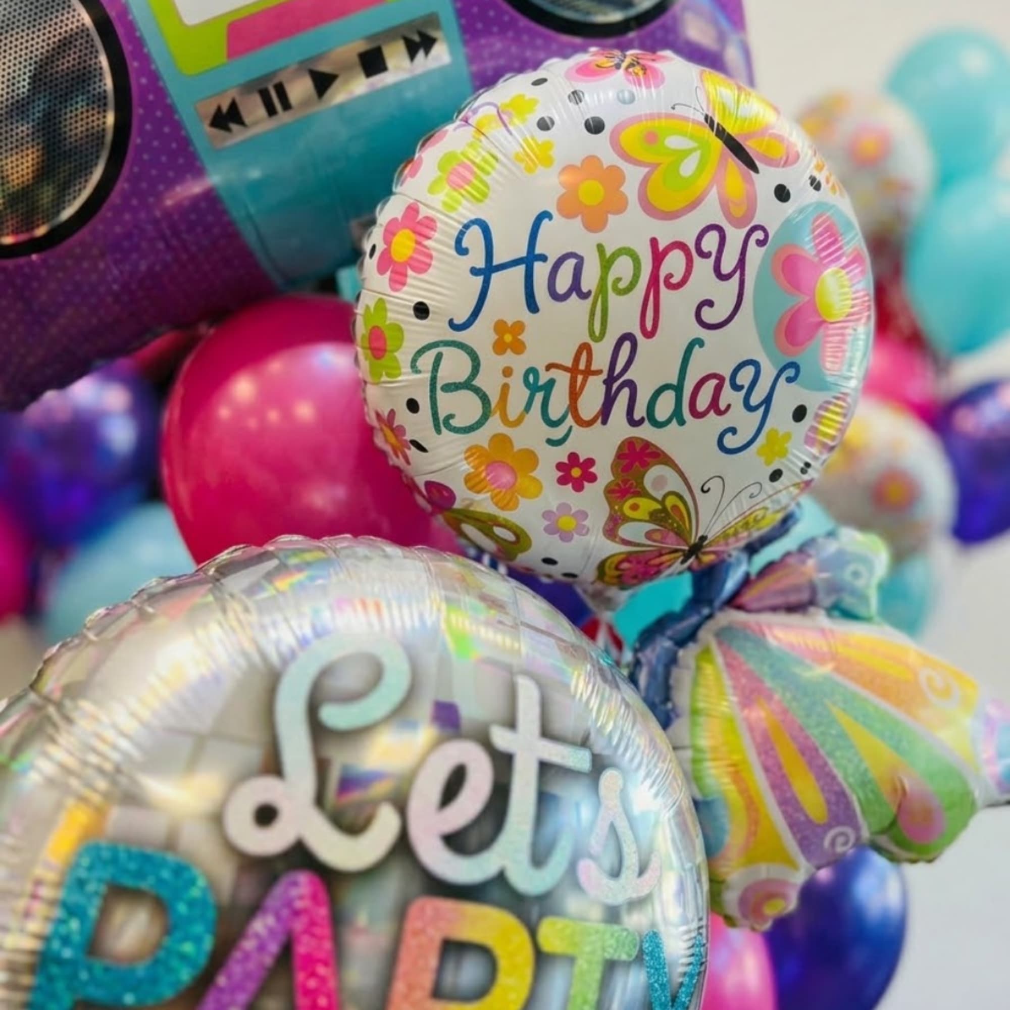 Birthday balloons with floral patterns and colorful lettering