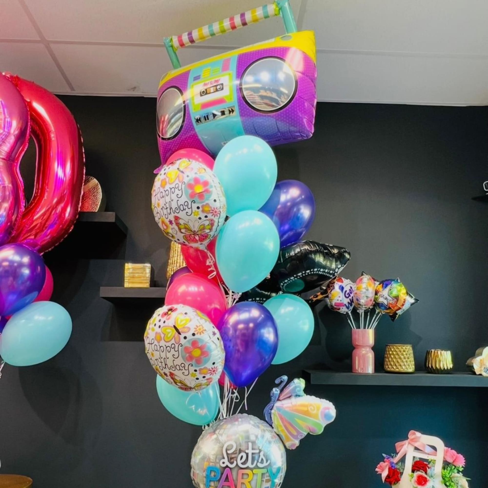 Birthday balloon bouquet with a boombox-shaped foil balloon and colorful latex balloons
