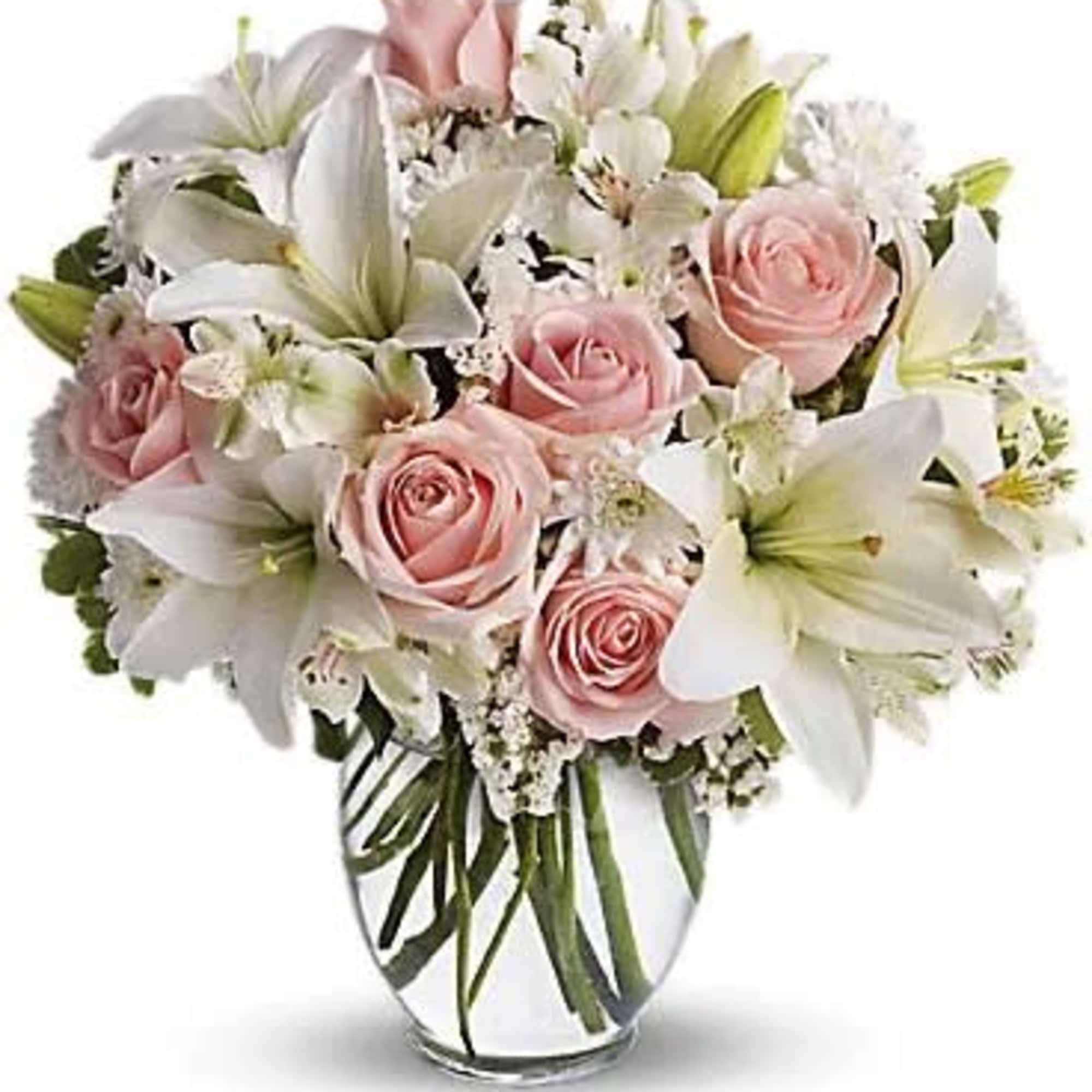 Pink roses and white lilies arranged in a clear glass vase, photo 3 of 3