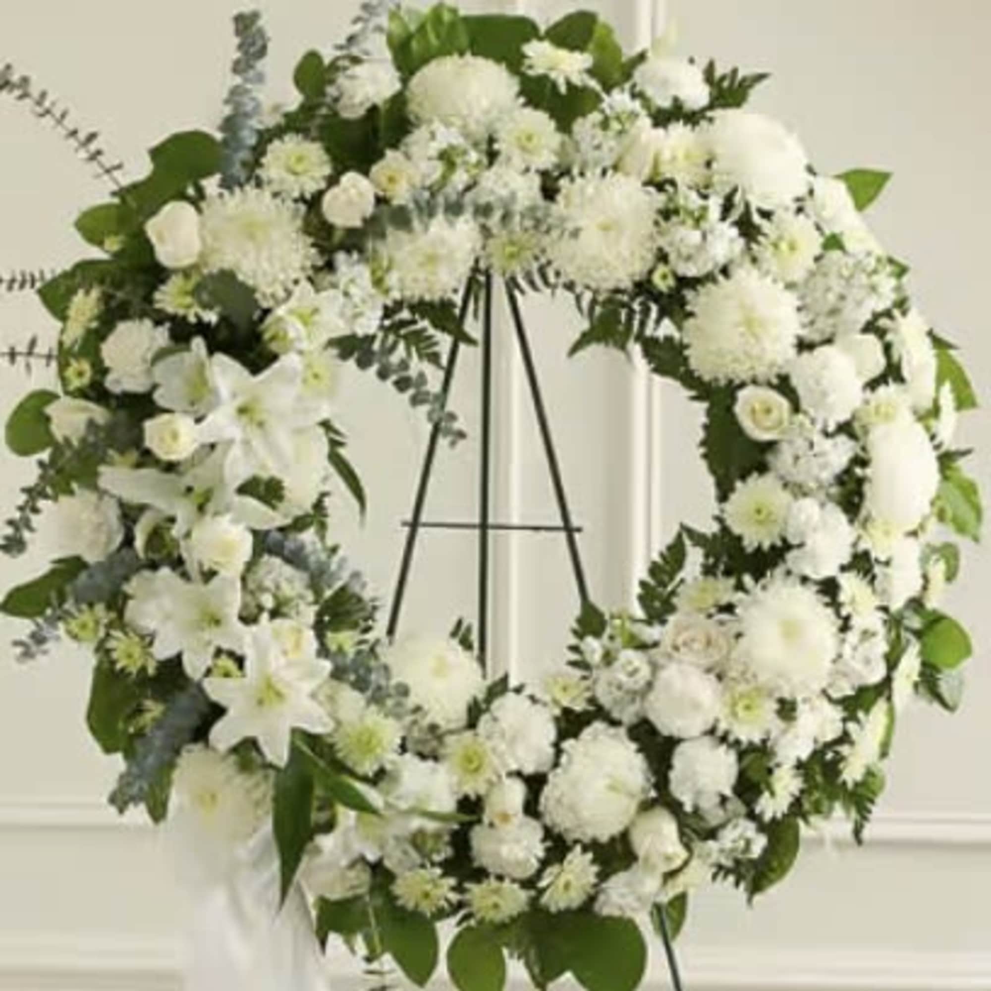 White floral wreath on a black easel