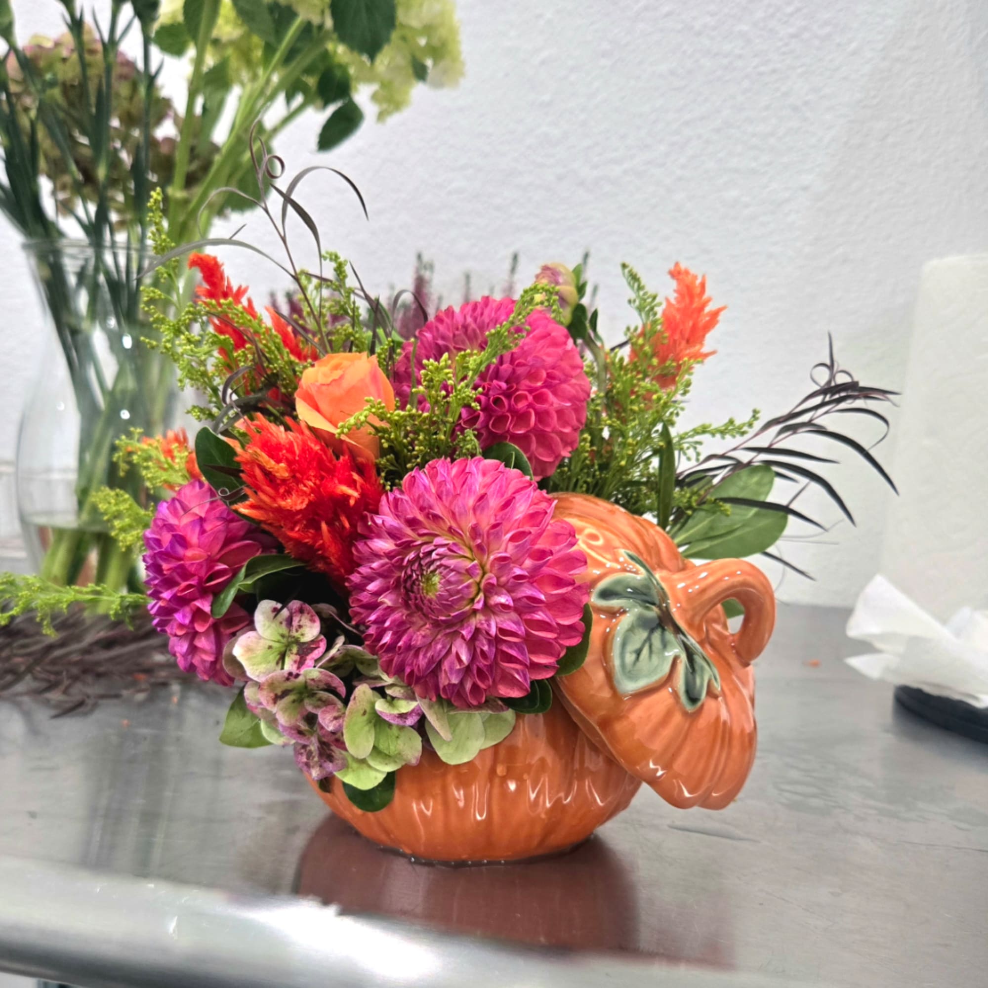 Bright mixed bouquet in an orange pumpkin-shaped vase