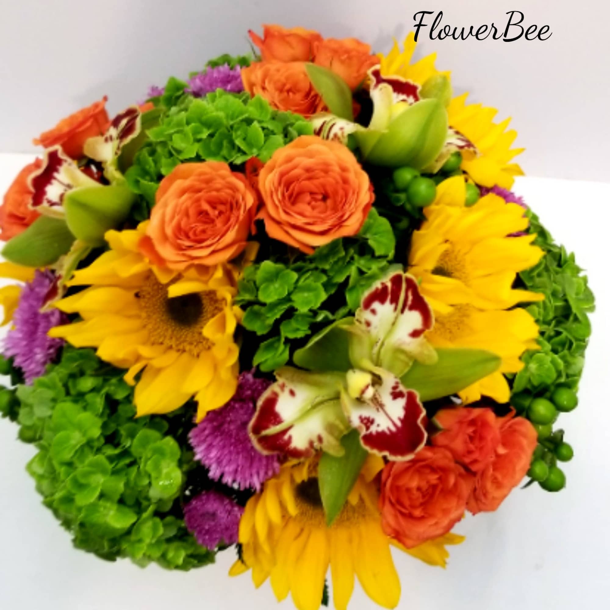 Round arrangement of yellow sunflowers, orange roses, green hydrangeas, orchids and purple mums