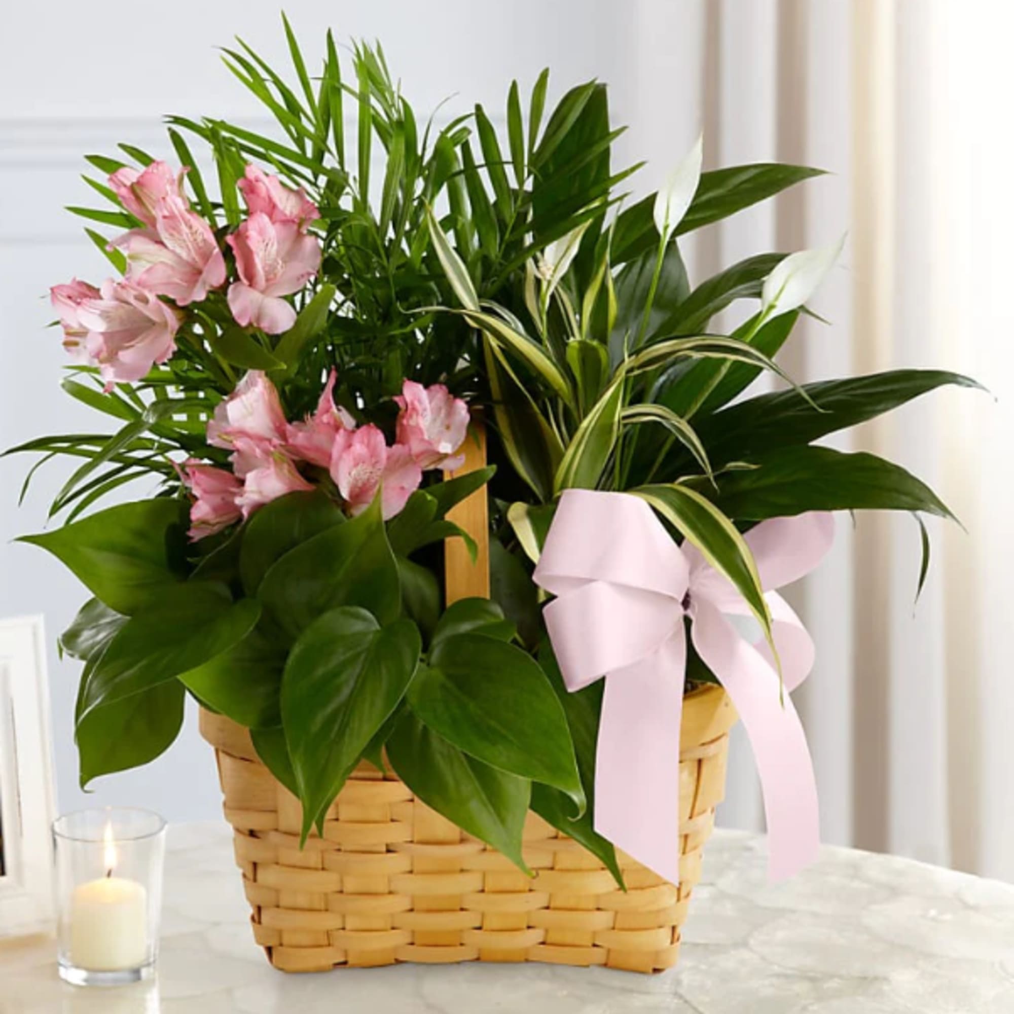 Pink flowers in a woven basket with a pink ribbon