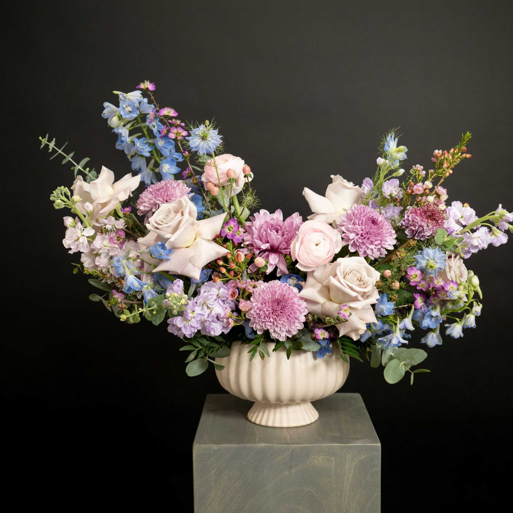 Pastel floral arrangement in a white urn vase