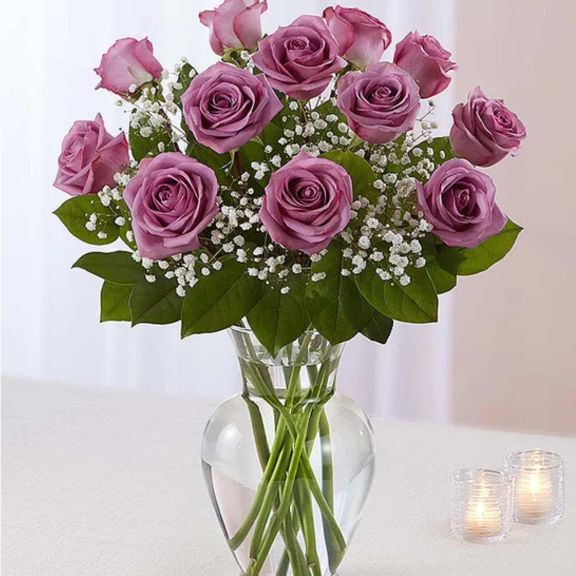 Pink roses arranged in a clear glass vase with baby's breath