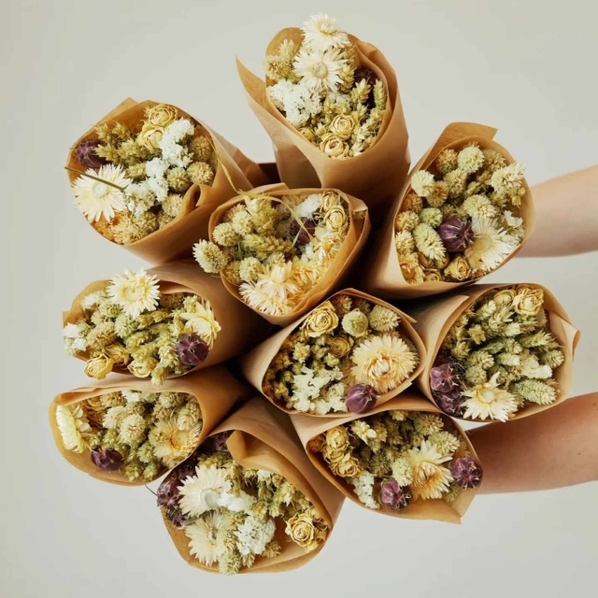 Cluster of small dried flower bouquets wrapped in brown paper