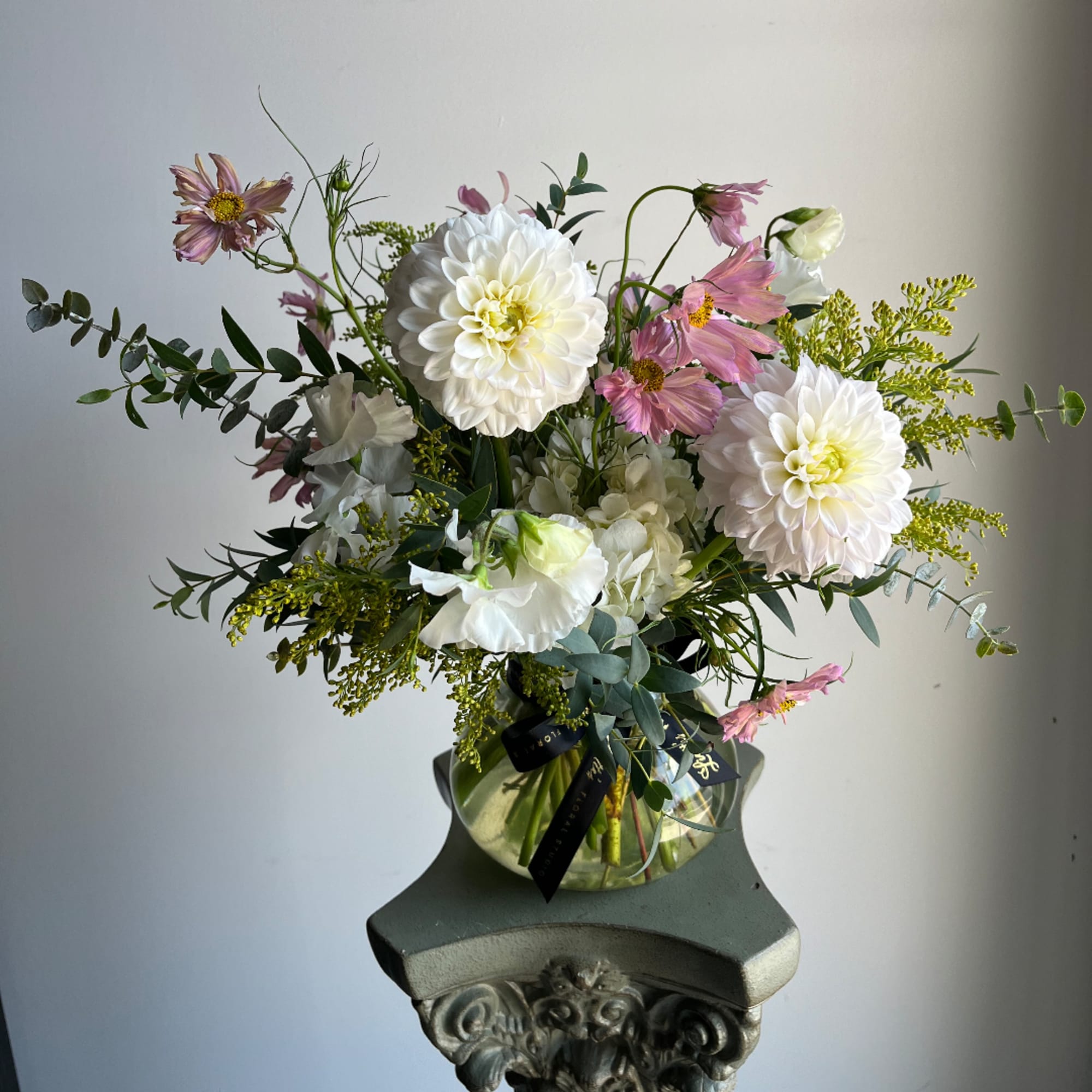 White and pink mixed bouquet in a glass vase on a pedestal