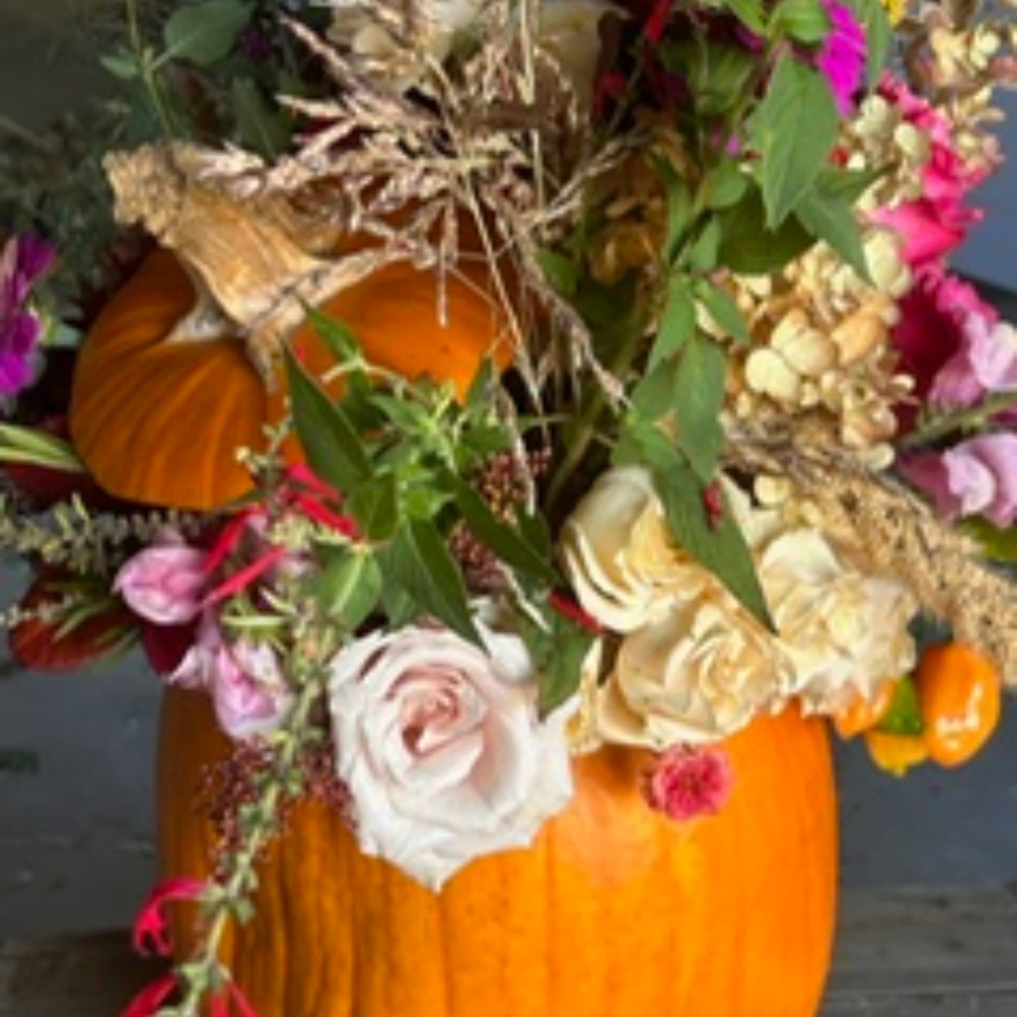 Pumpkin arrangement with roses and mixed flowers