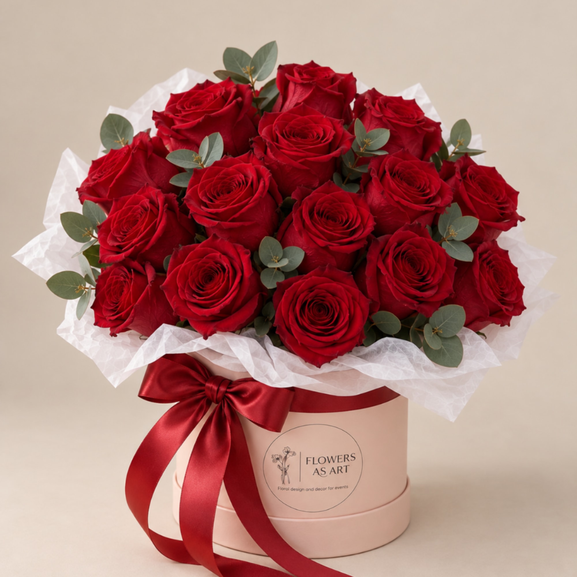 Red roses arranged in a pink hat box with a satin ribbon
